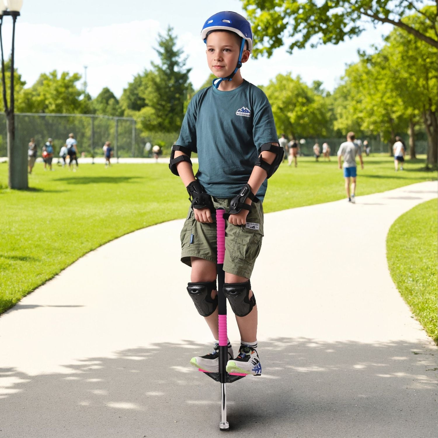 Niño en pogo stick en el parque, con casco y equipo de protección.