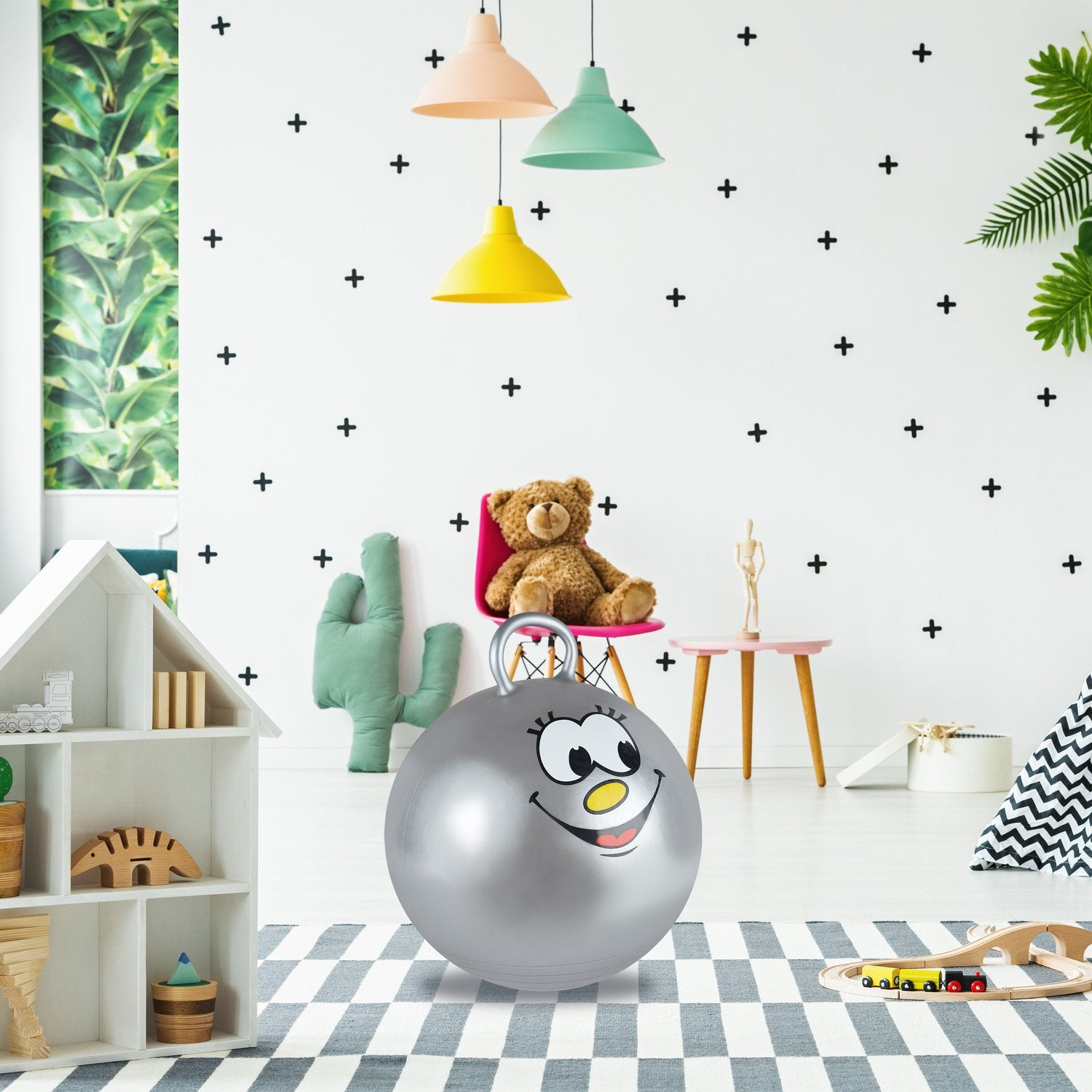 Una pelota plateada con cara está sobre una alfombra en una habitación infantil.