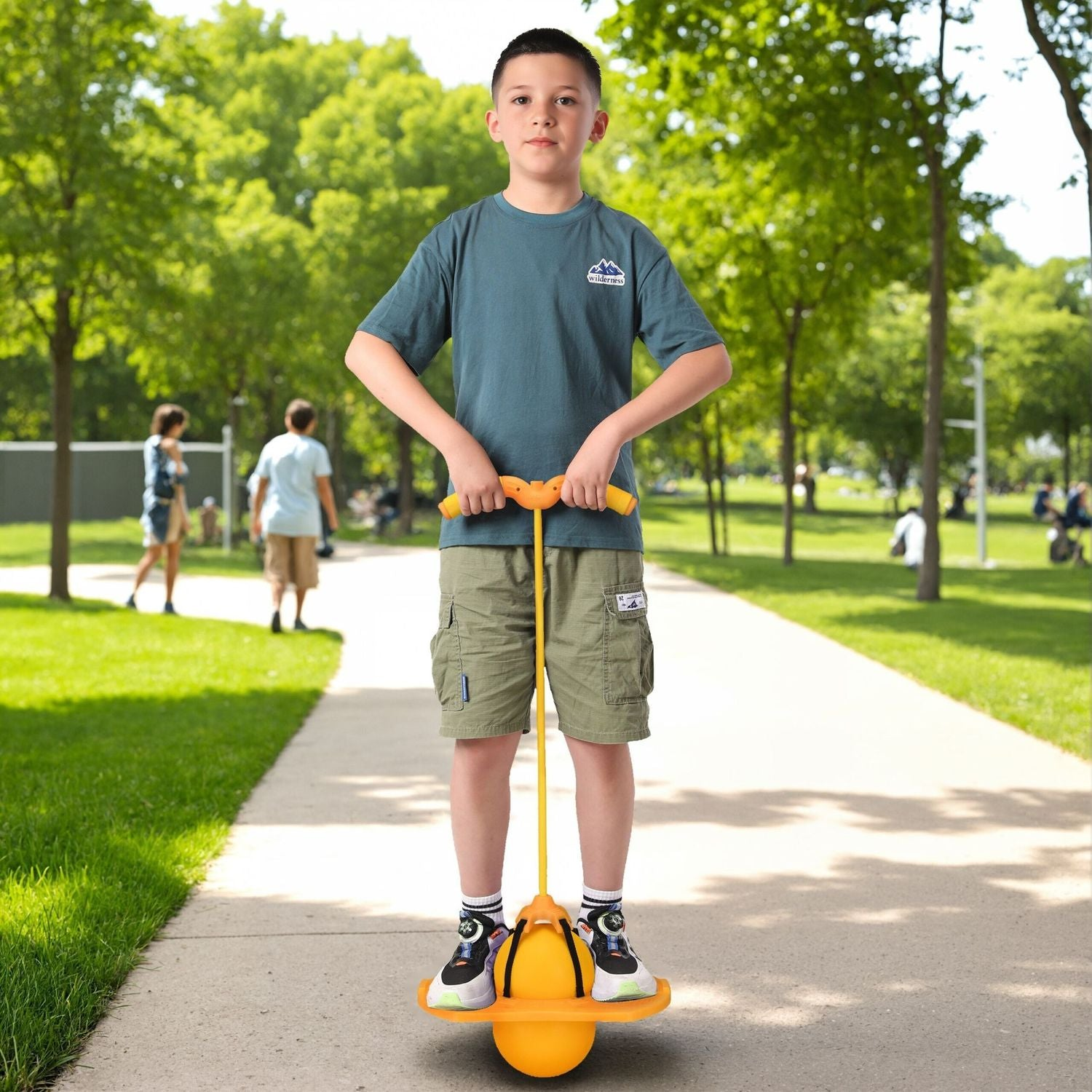 Un niño se para en un pogo stick en un camino del parque.