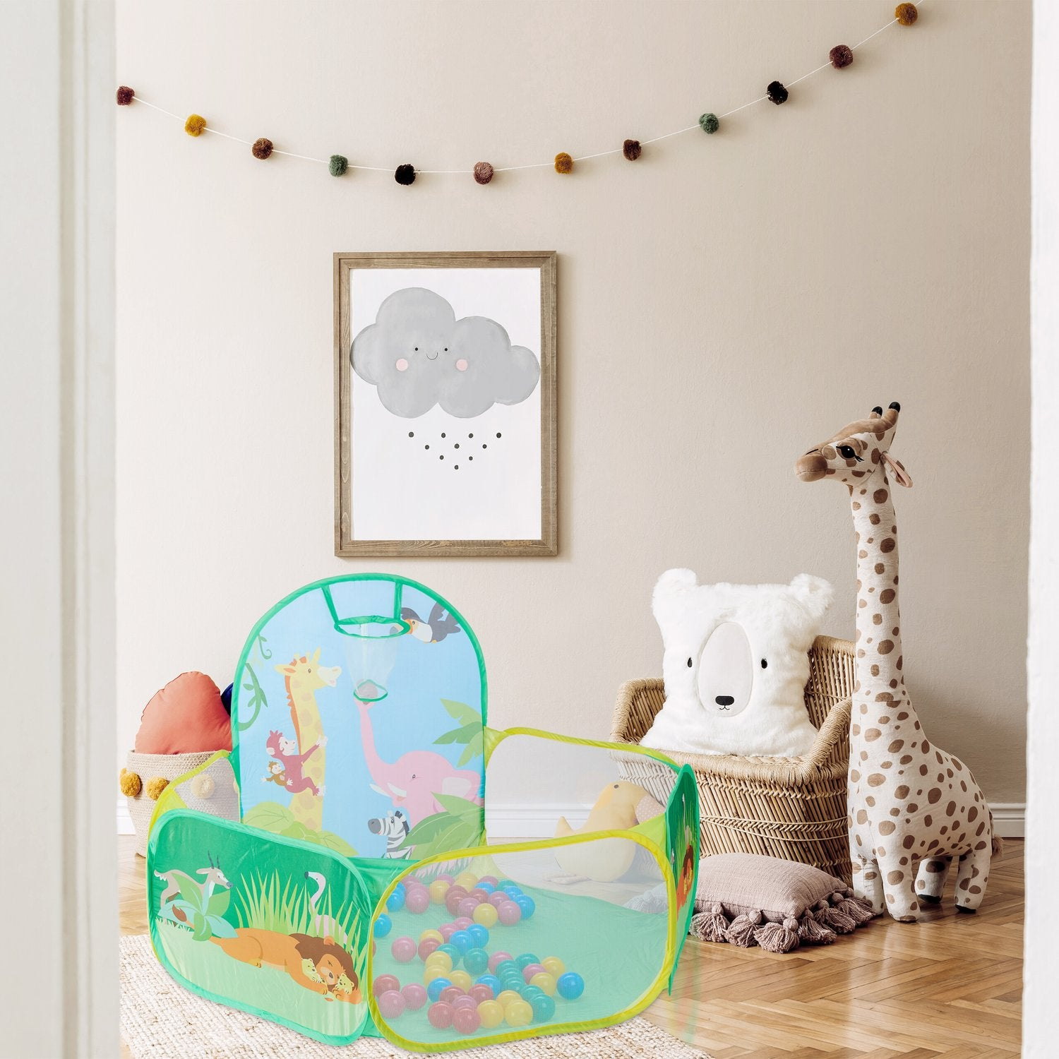 Una carpa de juegos con animales de la selva, pelotas y peluches en una habitación infantil.