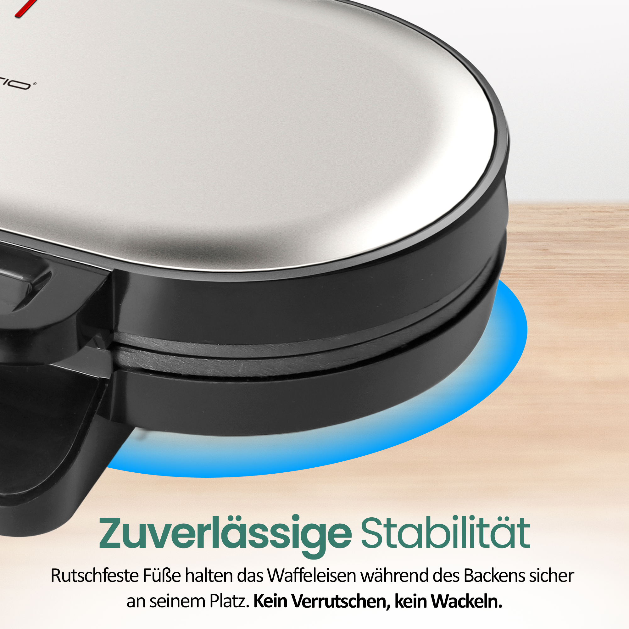 Ein silbernes Waffeleisen mit schwarzem Gehäuse steht auf einem Holztisch.