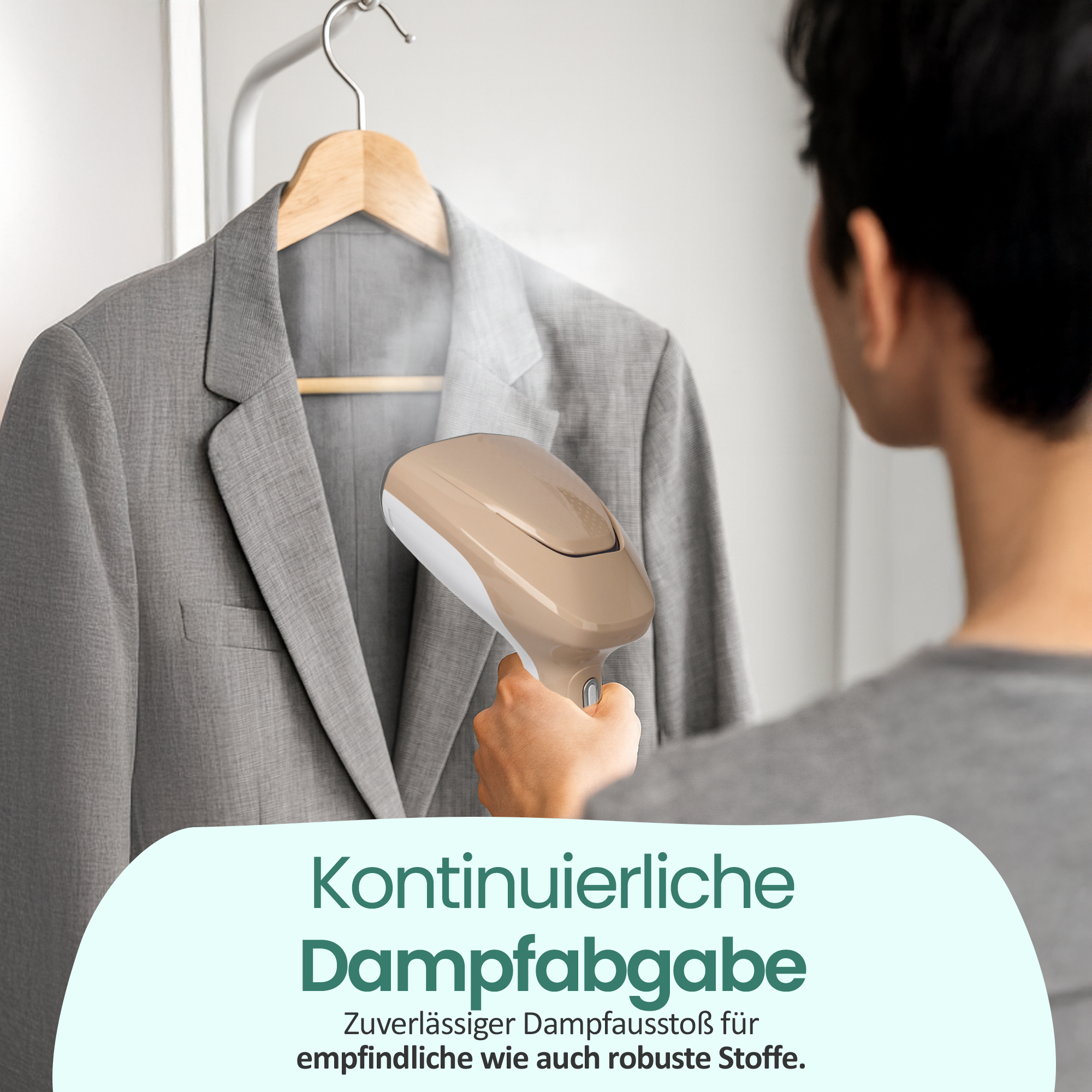 Ein Mann glättet einen grauen Anzug mit einem Handdampfer.