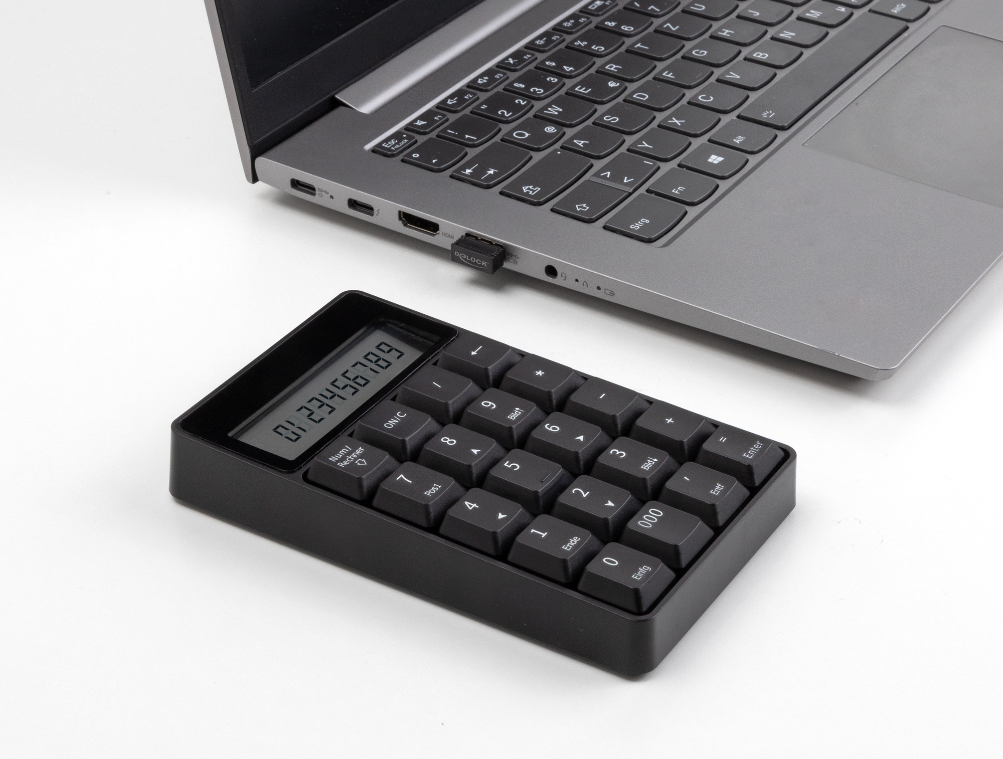 Ein schwarzer Nummernblock und ein Laptop mit einem USB-Dongle sind auf weißem Hintergrund.