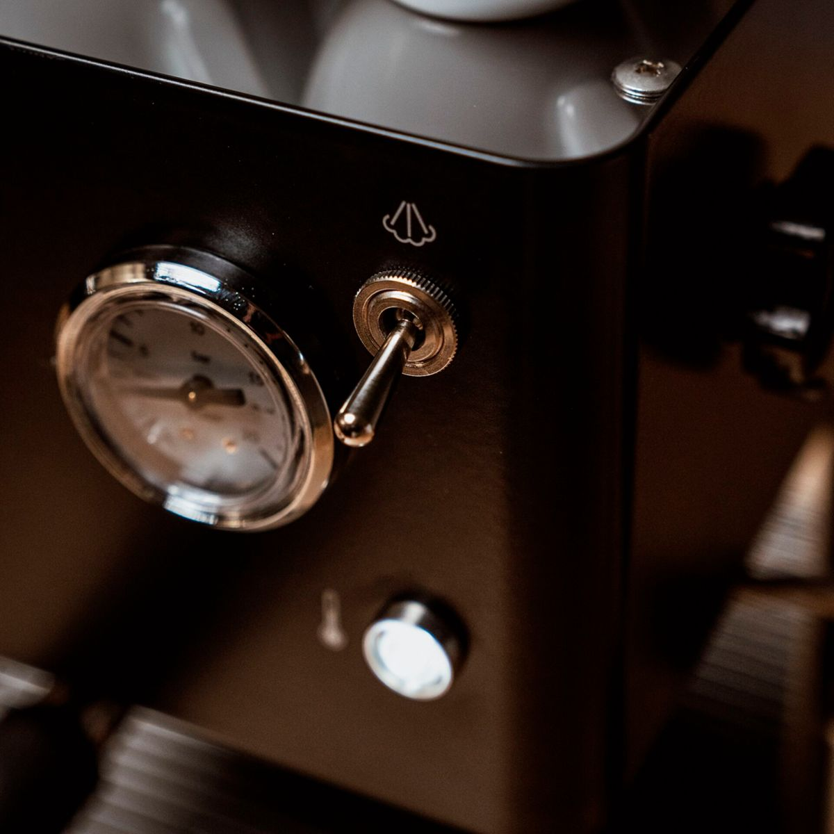 Nahaufnahme einer Espressomaschine mit Manometer und Kippschalter.