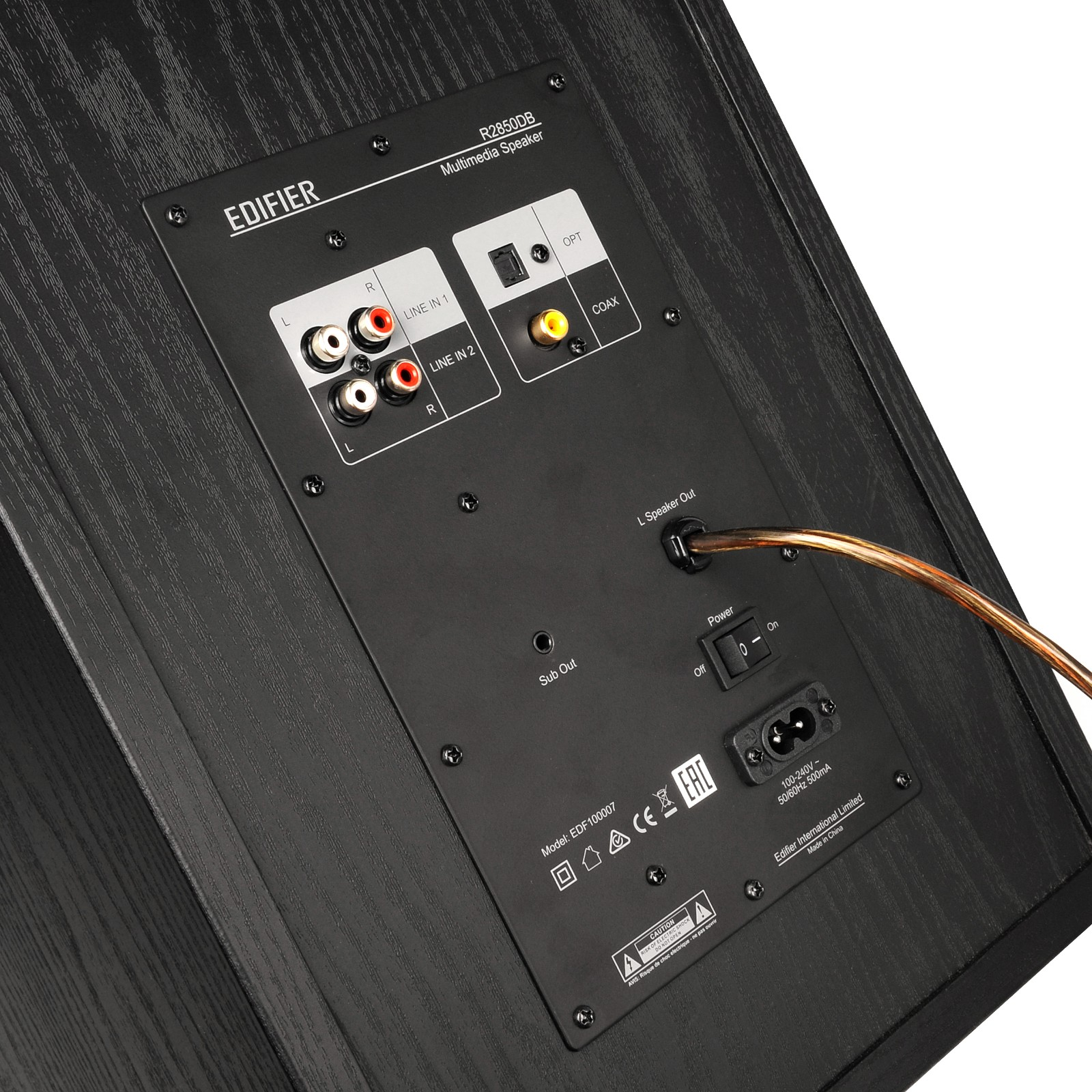 Tył czarnego głośnika z portami, przełącznikami i kablem.