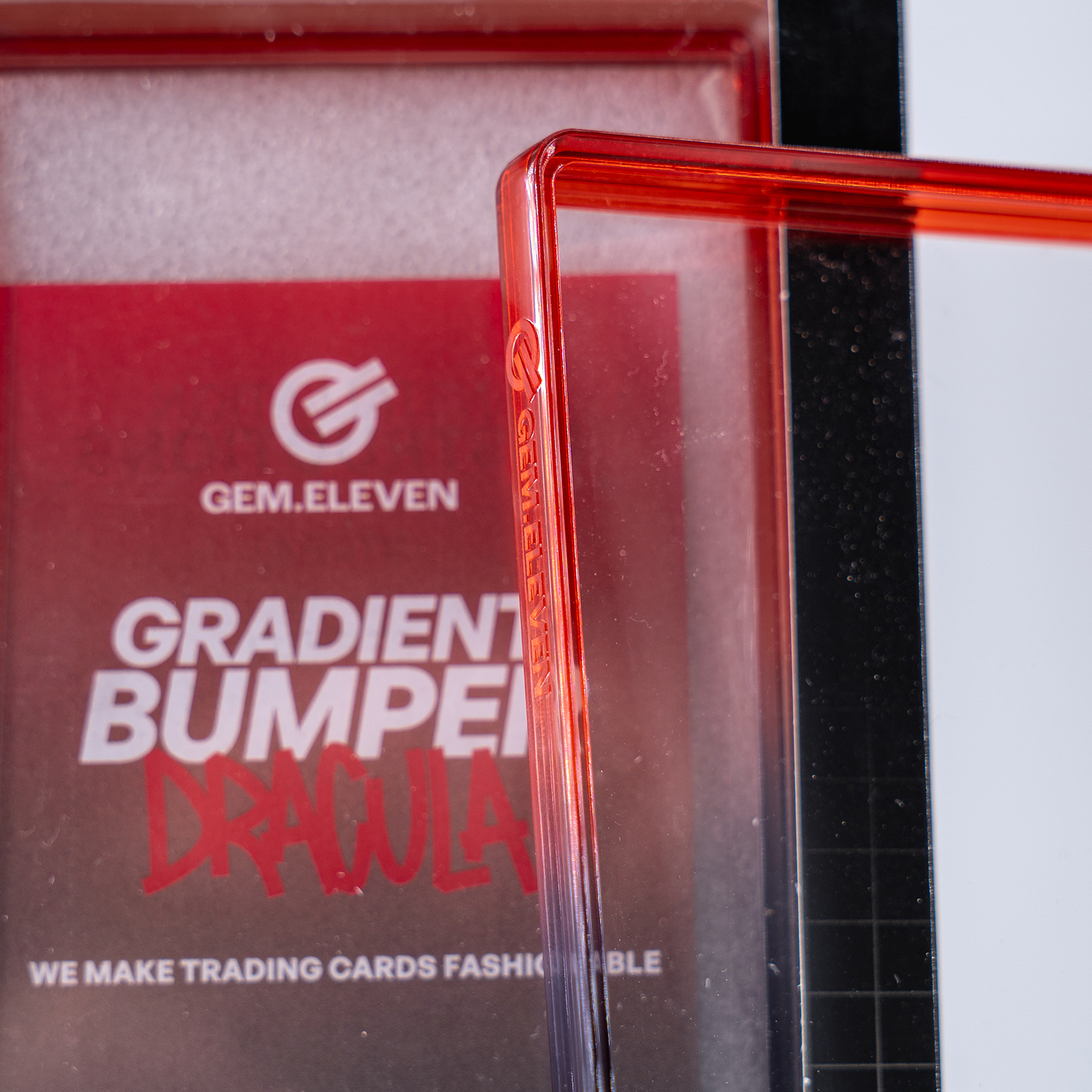 Ein roter, durchsichtiger Schutz für Sammelkarten mit dem GEM.ELEVEN Logo.