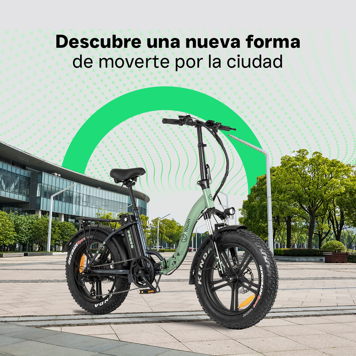 Una bici pieghevole verde chiaro con pneumatici larghi si trova su un marciapiede.