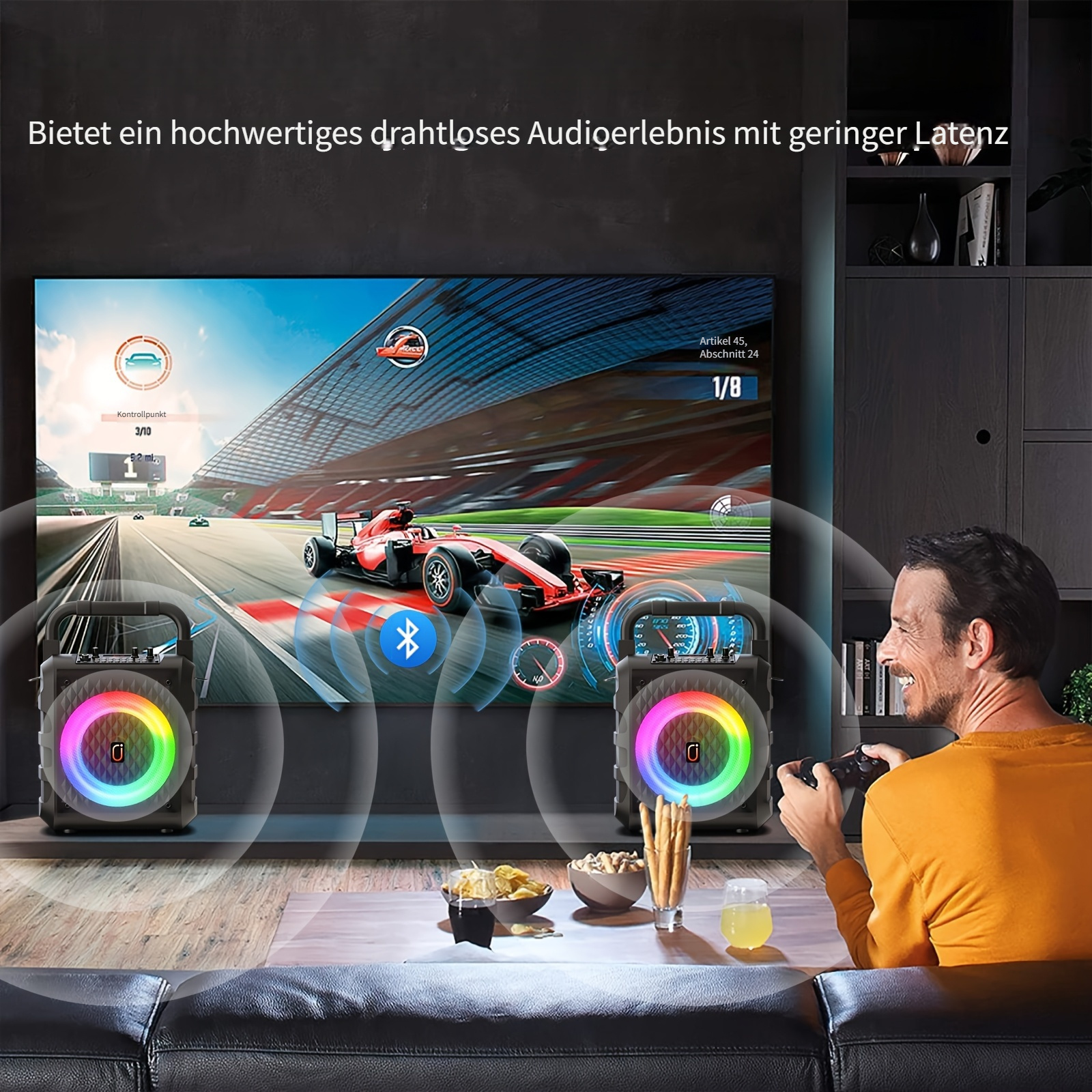 Mann spielt Videospiel, zwei Lautsprecher mit bunten Lichtern.