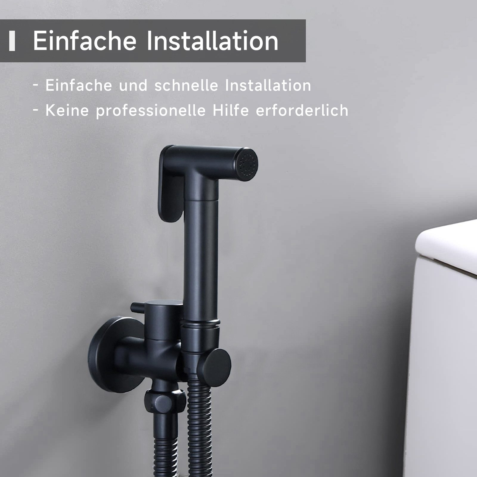 Schwarzer Bidet-Sprühkopf an einer grauen Wand neben einer Toilette.