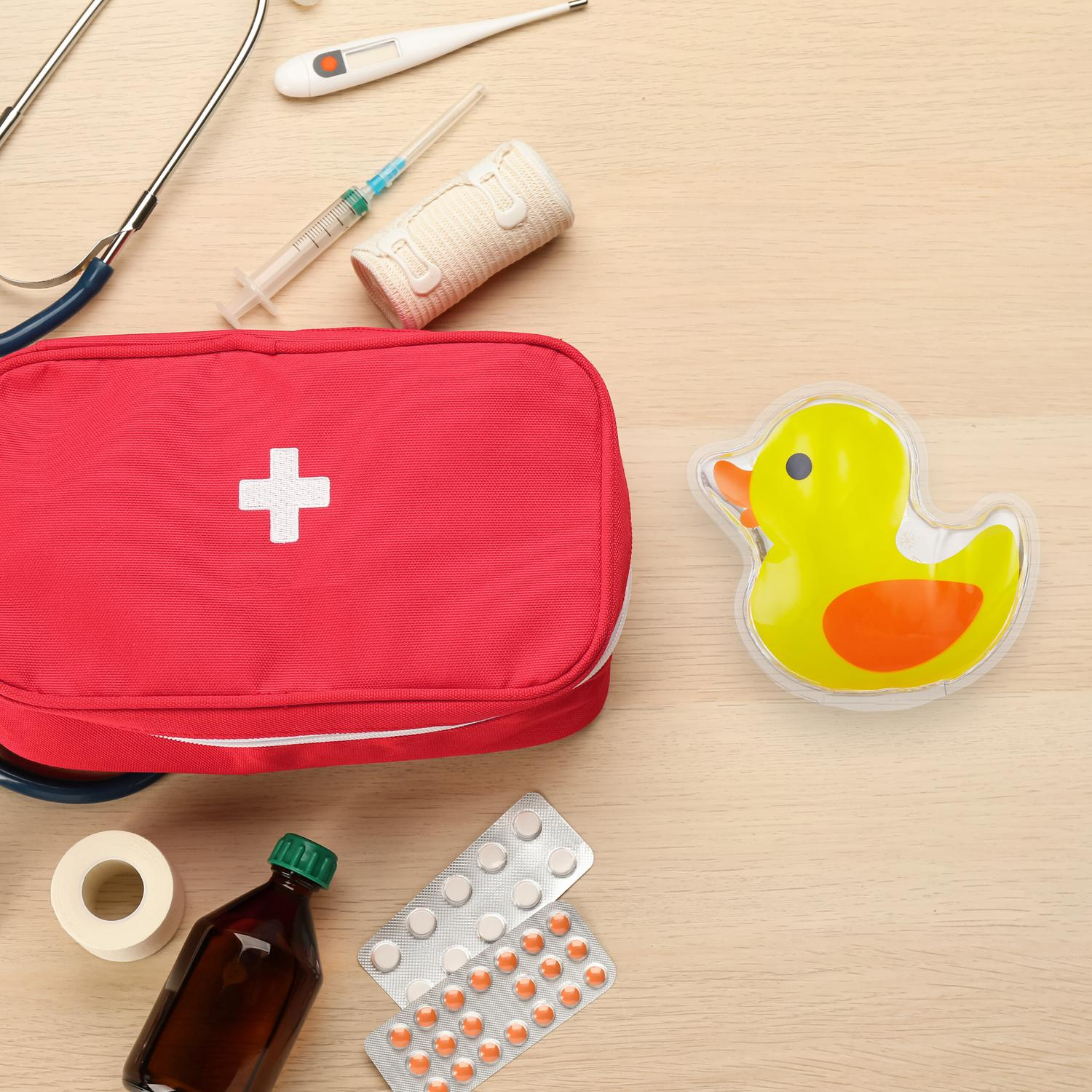 Botiquín rojo con suministros médicos y bolsa de agua caliente con forma de pato.