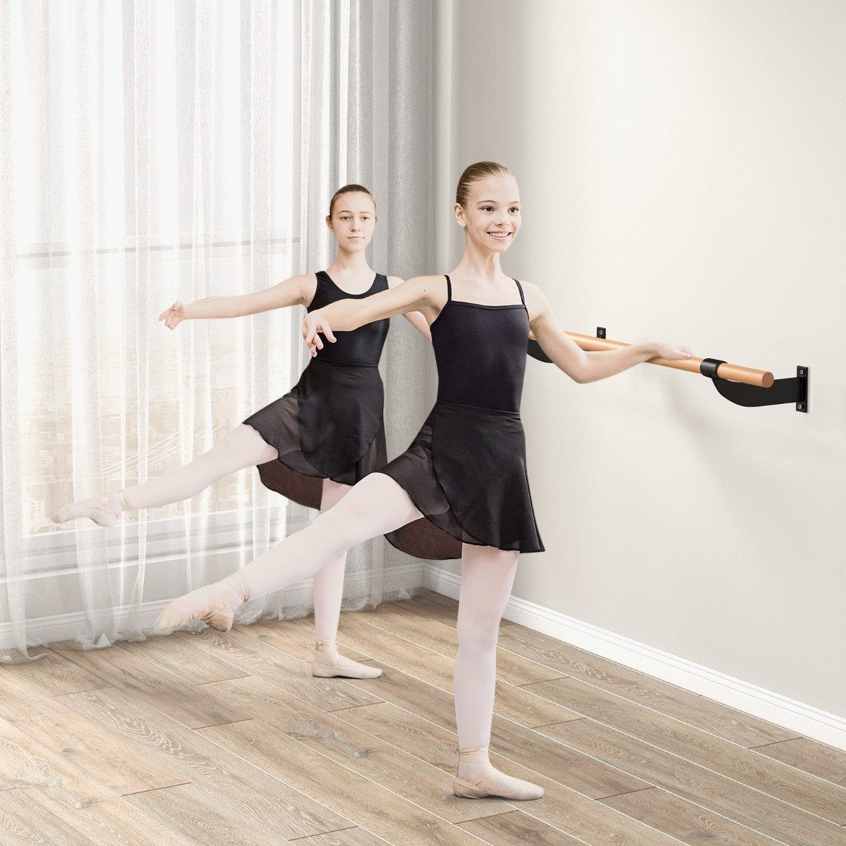 Dos jóvenes bailarinas con maillots y faldas negras practican en una barra de ballet.