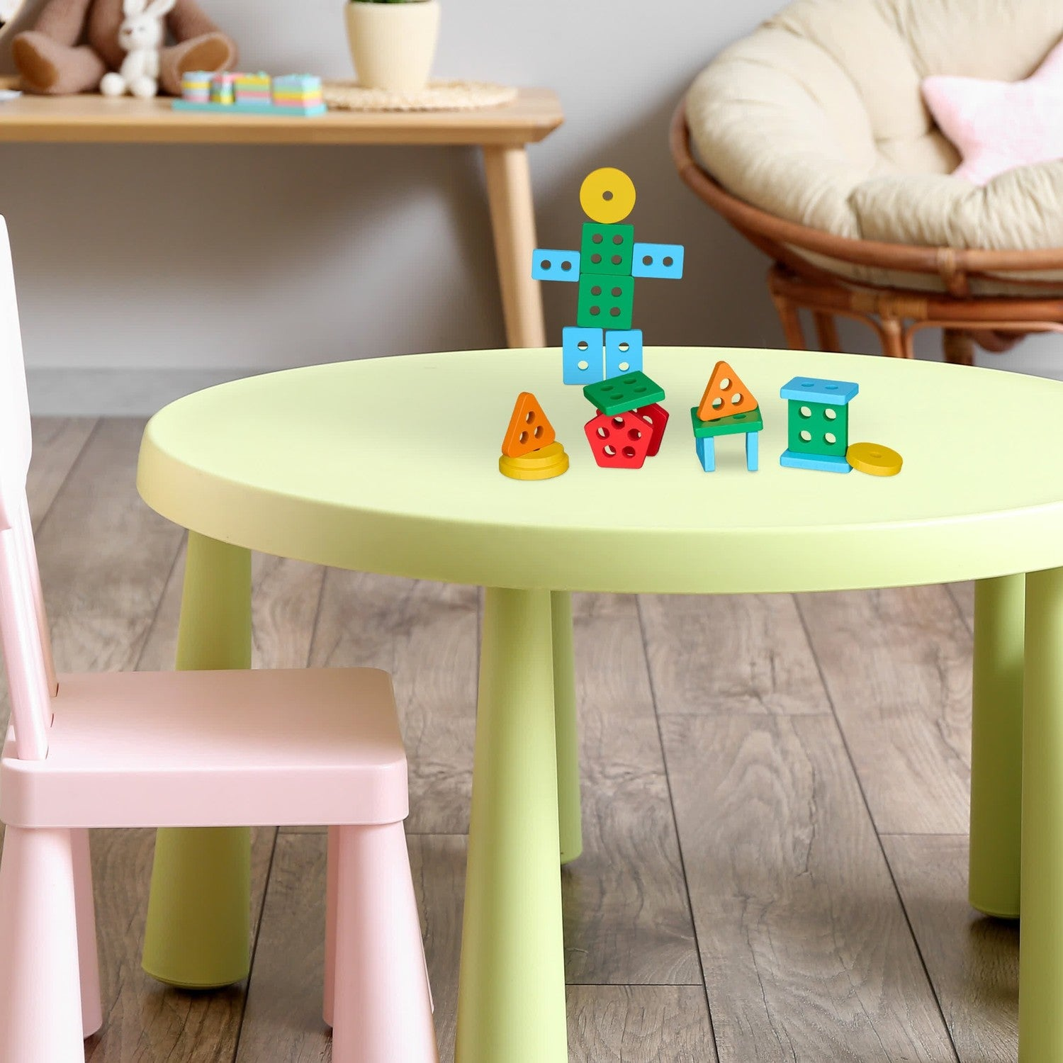 Bloques de construcción de madera coloridos en una mesa infantil verde claro con silla.