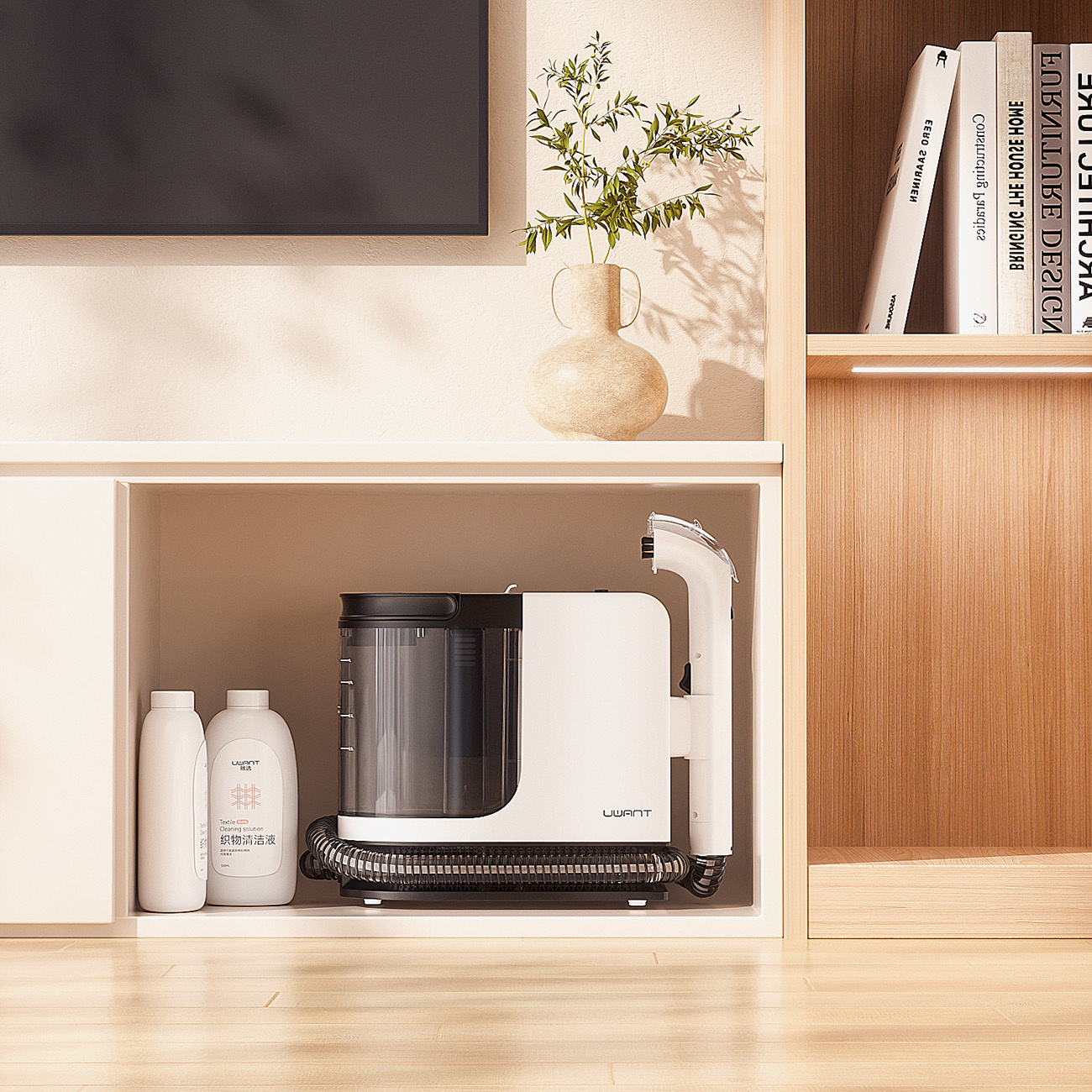 Białe urządzenie czyszczące z czarnym zbiornikiem i wężem obok dwóch butelek.