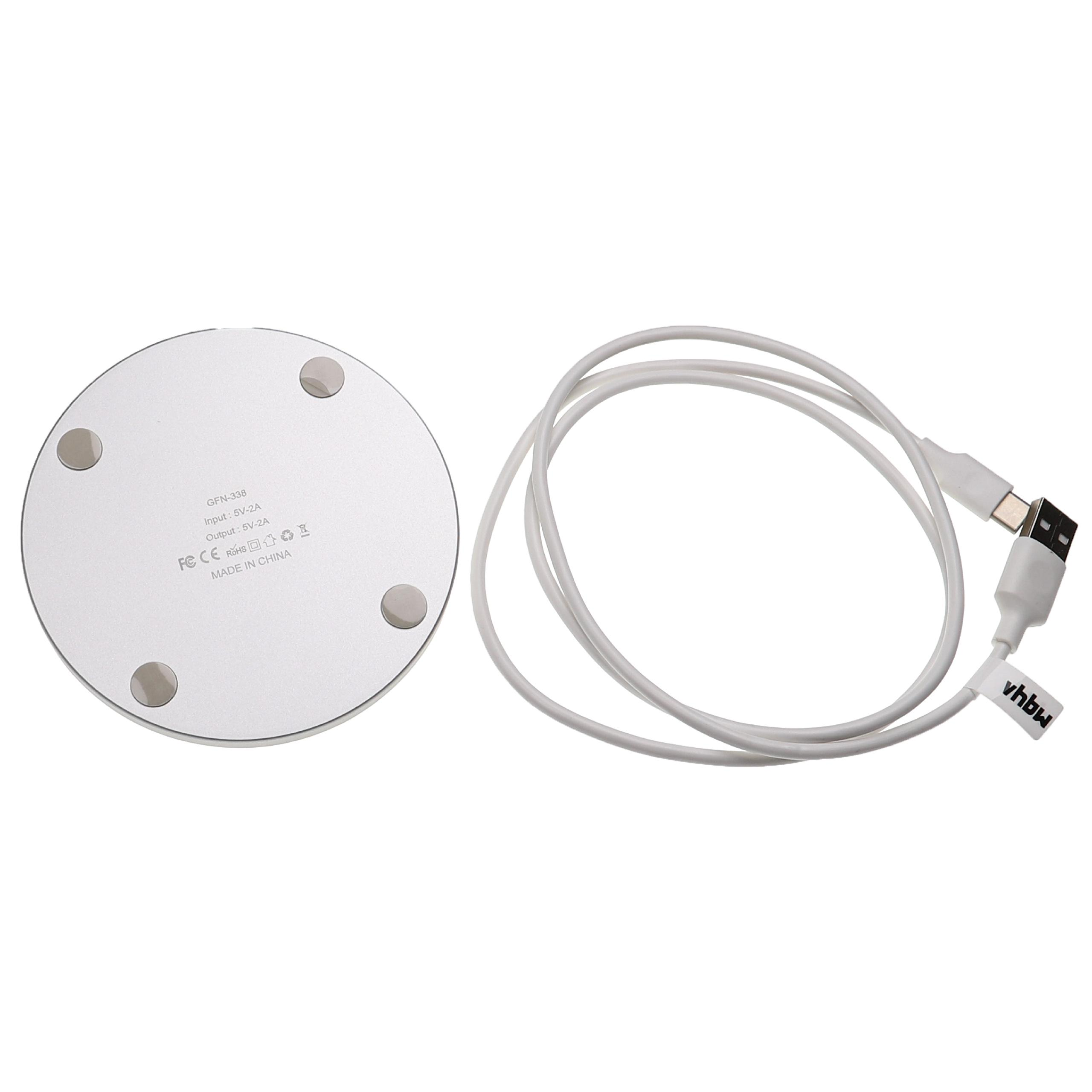 Ein silberner, runder Ladeadapter mit einem weißen USB-Kabel.