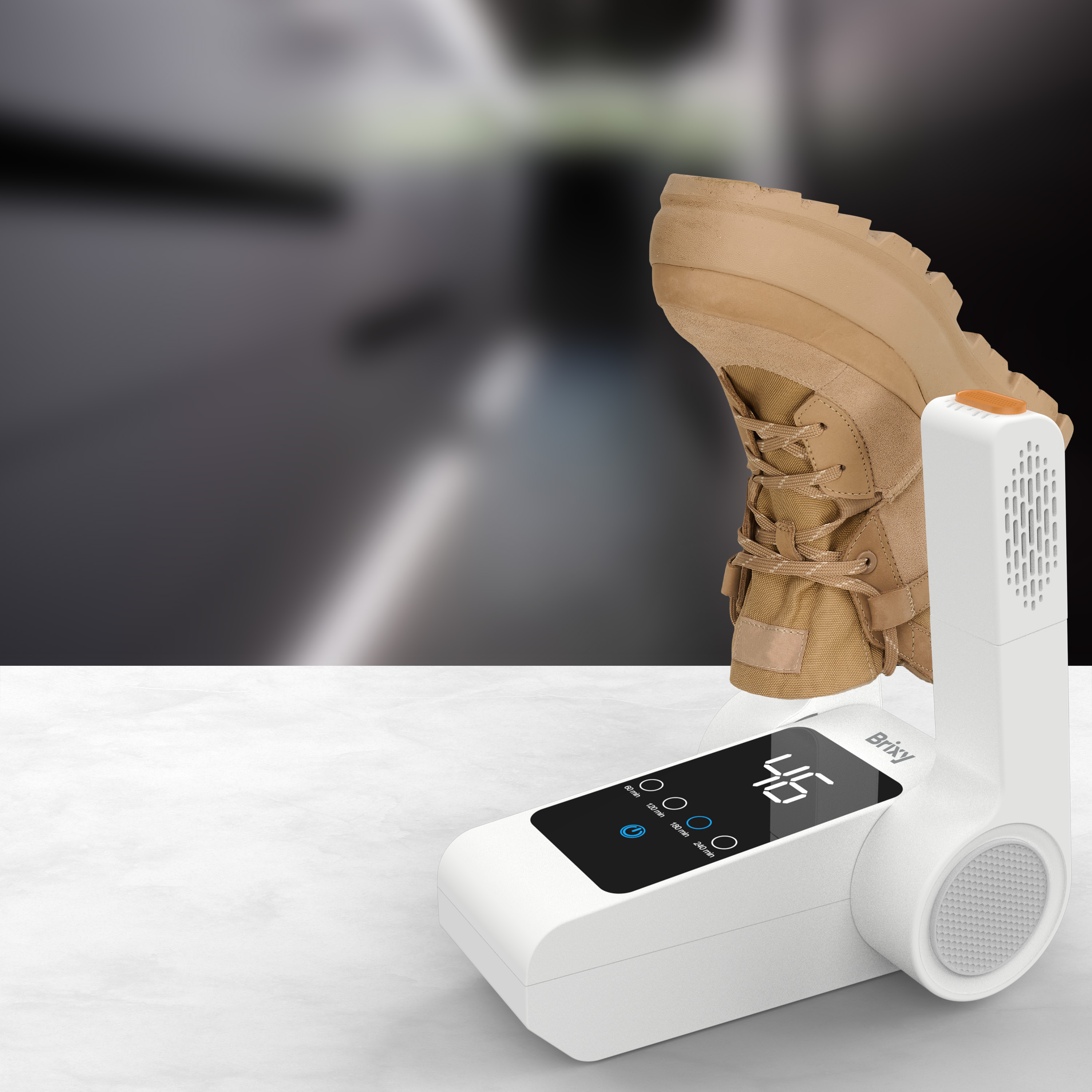 A tan boot stands on a white device with a black digital display.