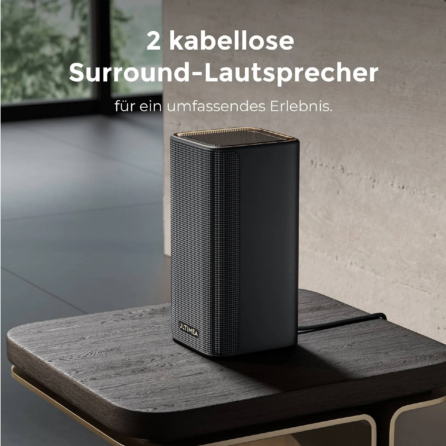 Une enceinte noire aux accents dorés est posée sur une table en bois.