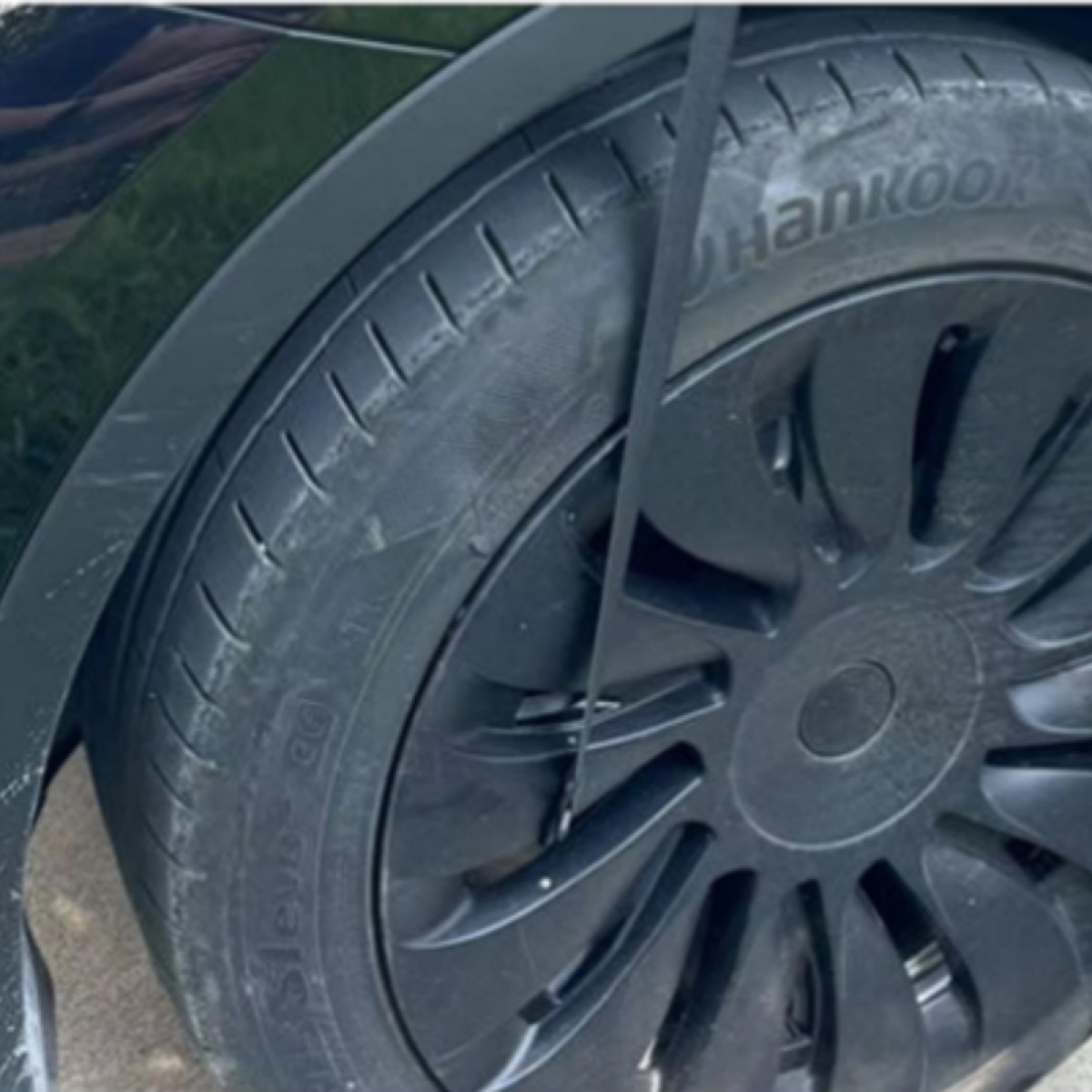 Ein schwarzes Auto-Rad mit Hankook-Reifen und schwarzer Felge.