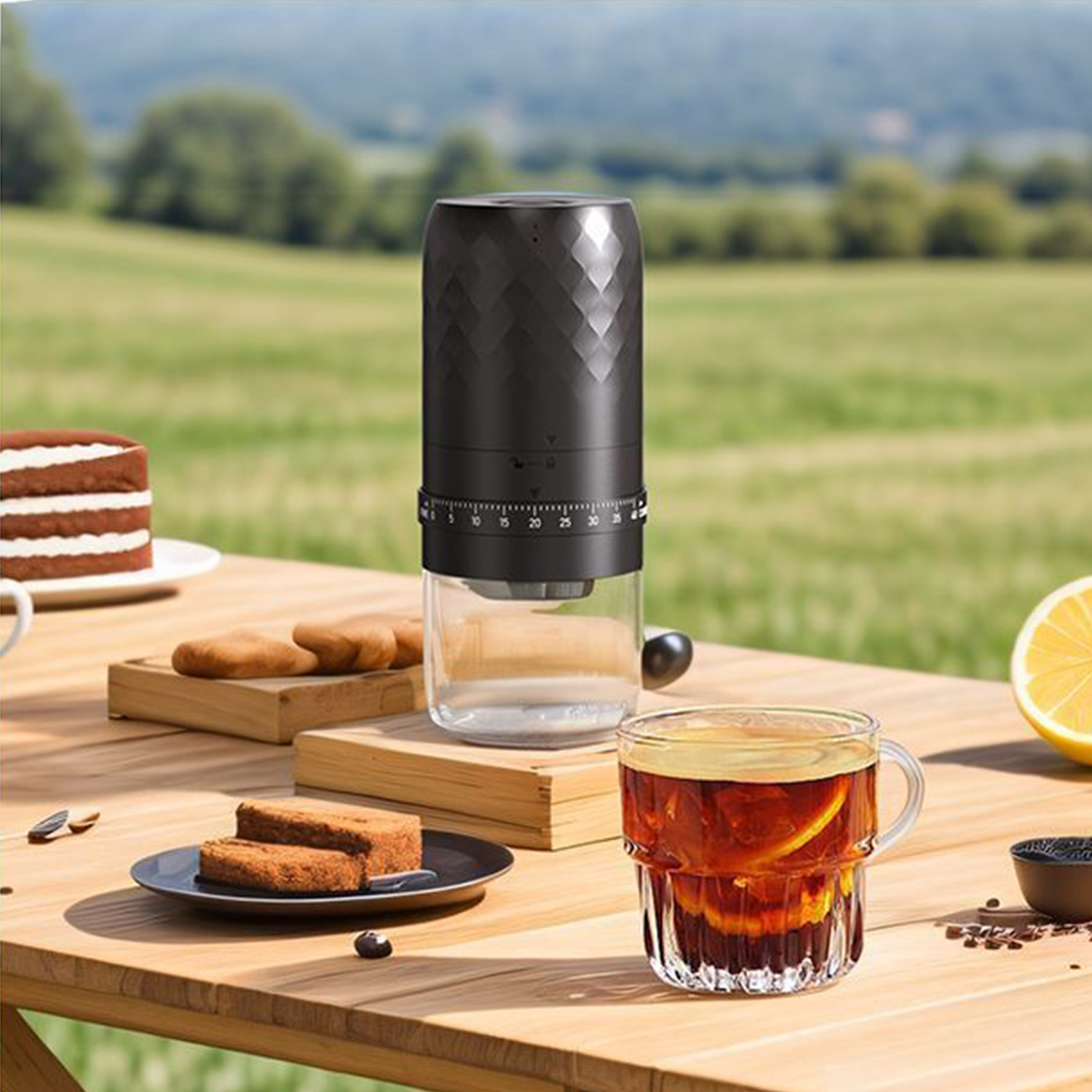 Czarny młynek do kawy na drewnianym stole z ciastem i szklanką herbaty.