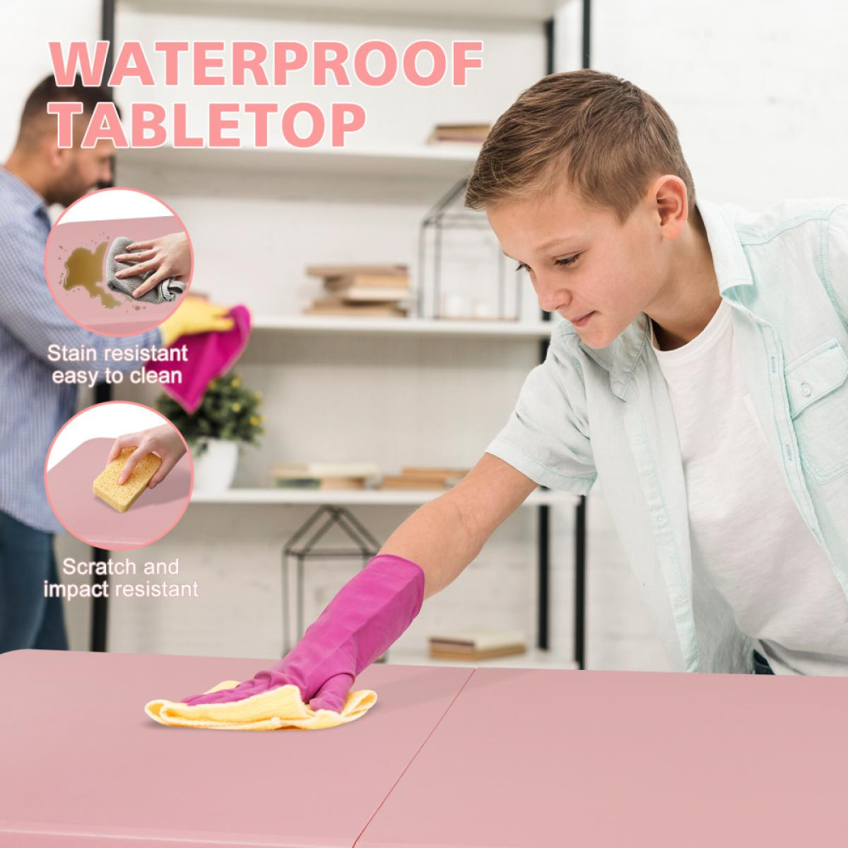 Ein Junge putzt eine rosa Tischplatte mit einem gelben Tuch.