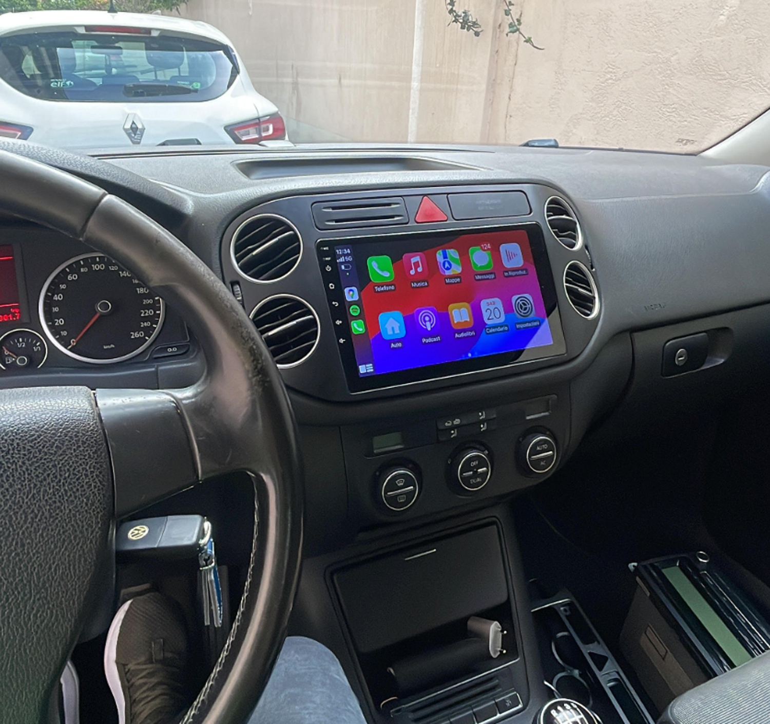 Innenansicht eines Autos mit Infotainment-Bildschirm, Lenkrad und Armaturenbrett.