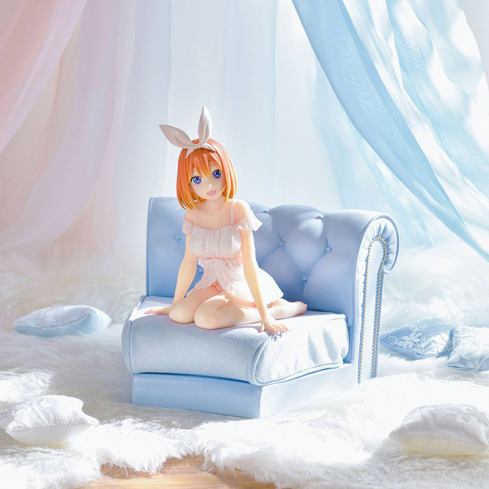 Anime-Figur mit Hasenohren sitzt auf einer hellblauen Couch, umgeben von flauschigem Teppich.
