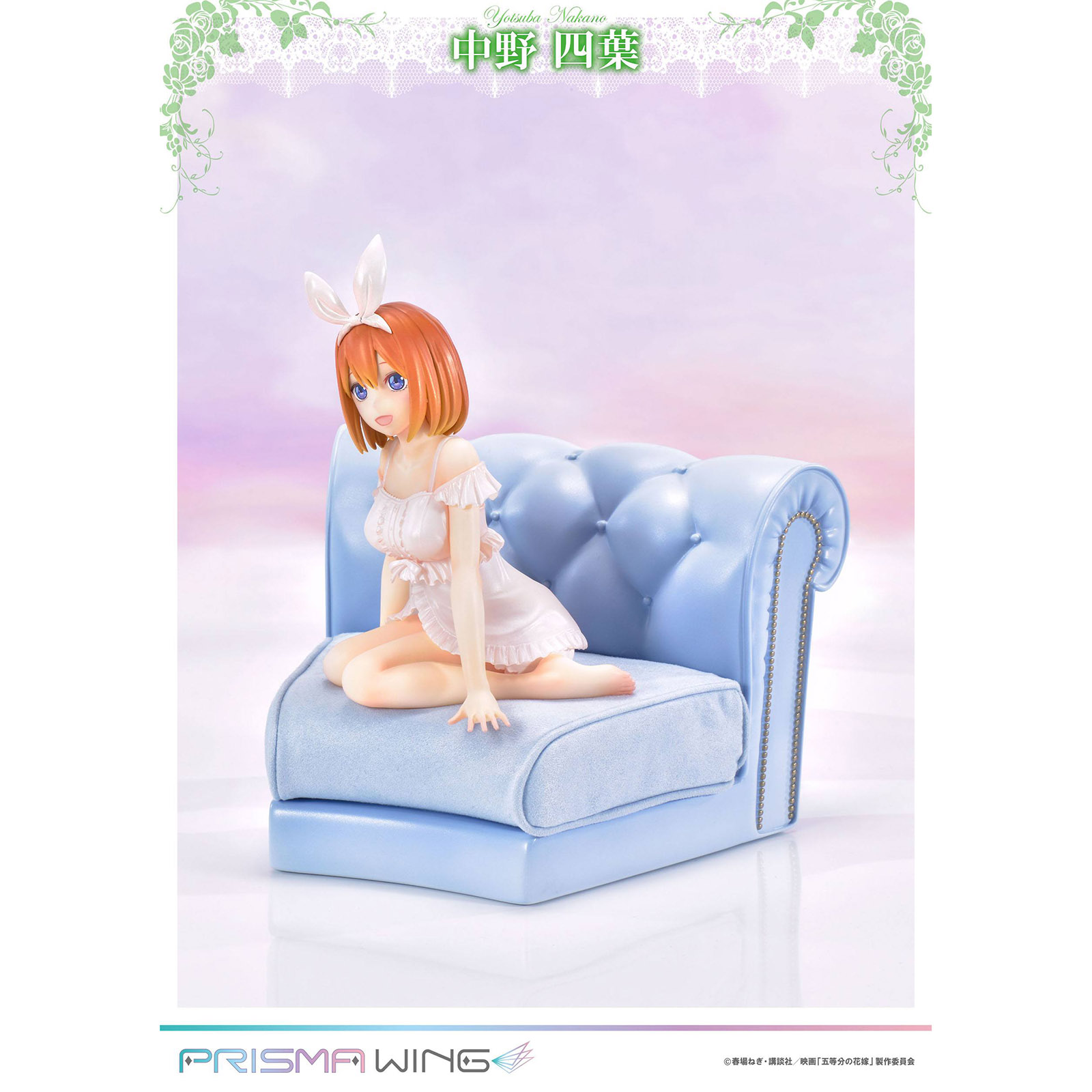 Anime-Figur von Yotsuba Nakano mit Hasenohren sitzt auf einem blauen Sofa.