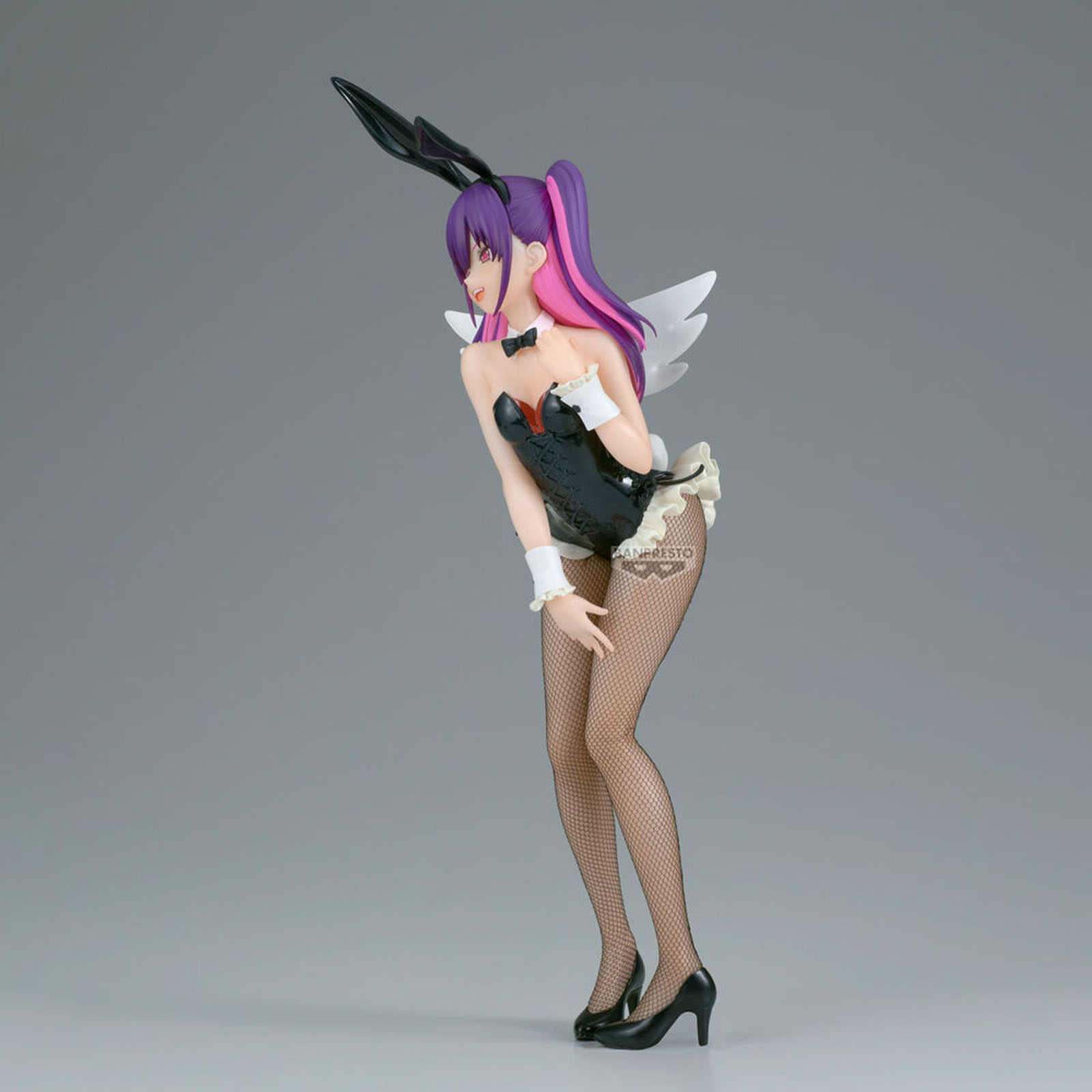 Figura de mujer con pelo morado, orejas de conejo y alas en traje negro.