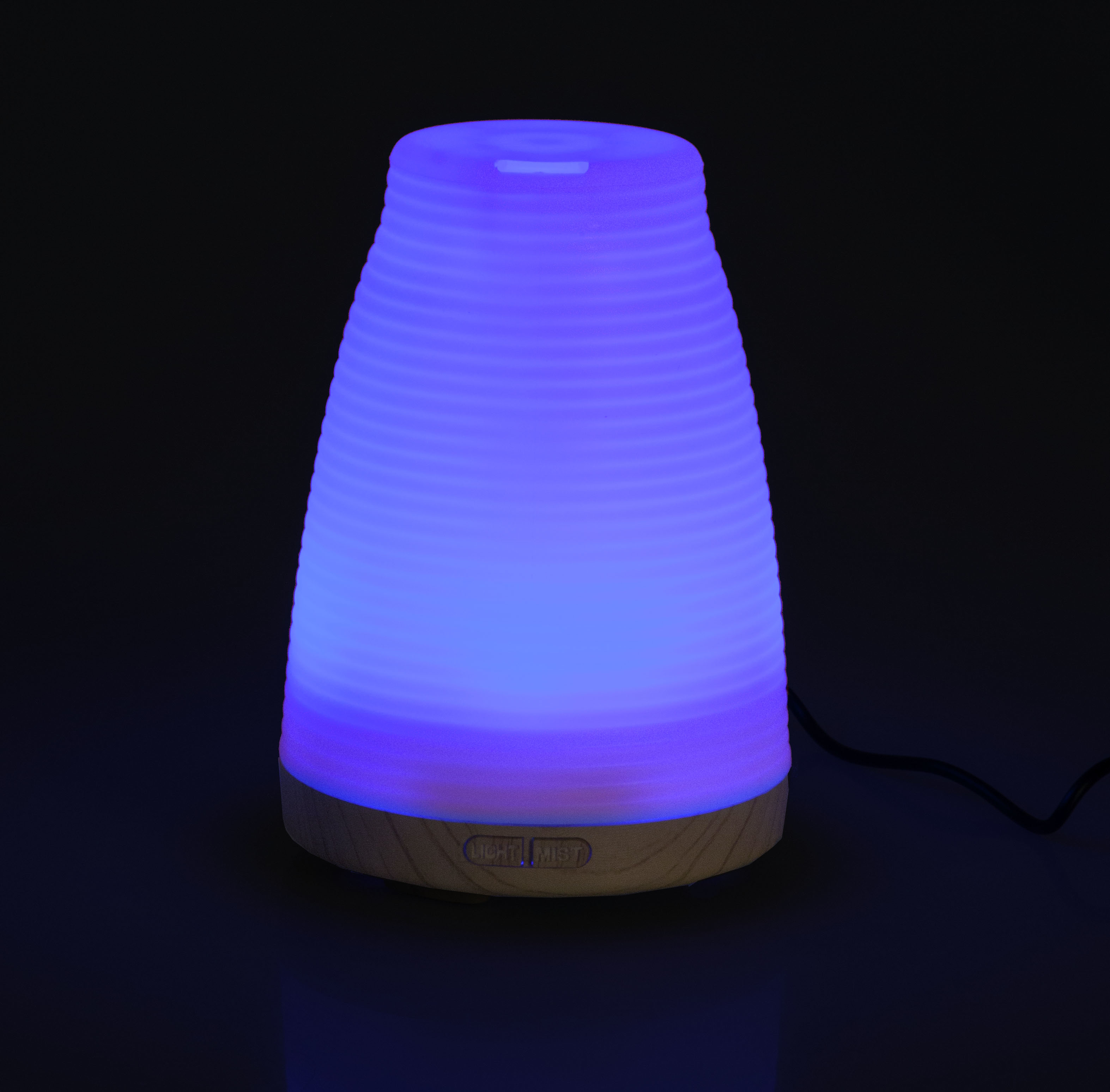 Ein beleuchteter Diffusor mit Wellenmuster leuchtet in Blau- und Lilatönen.
