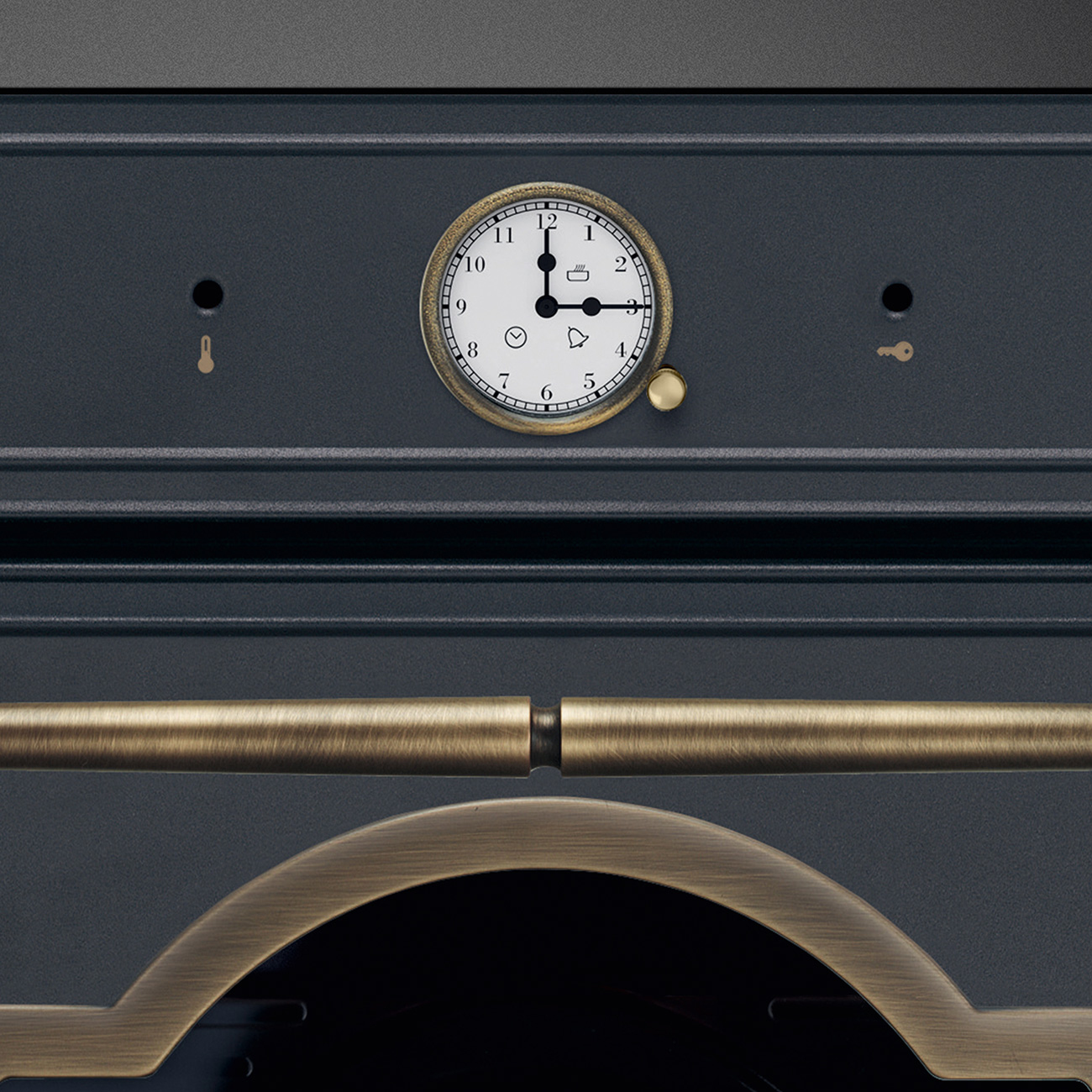 Un primer plano de un horno gris oscuro con pantalla de reloj redonda y asas de latón.