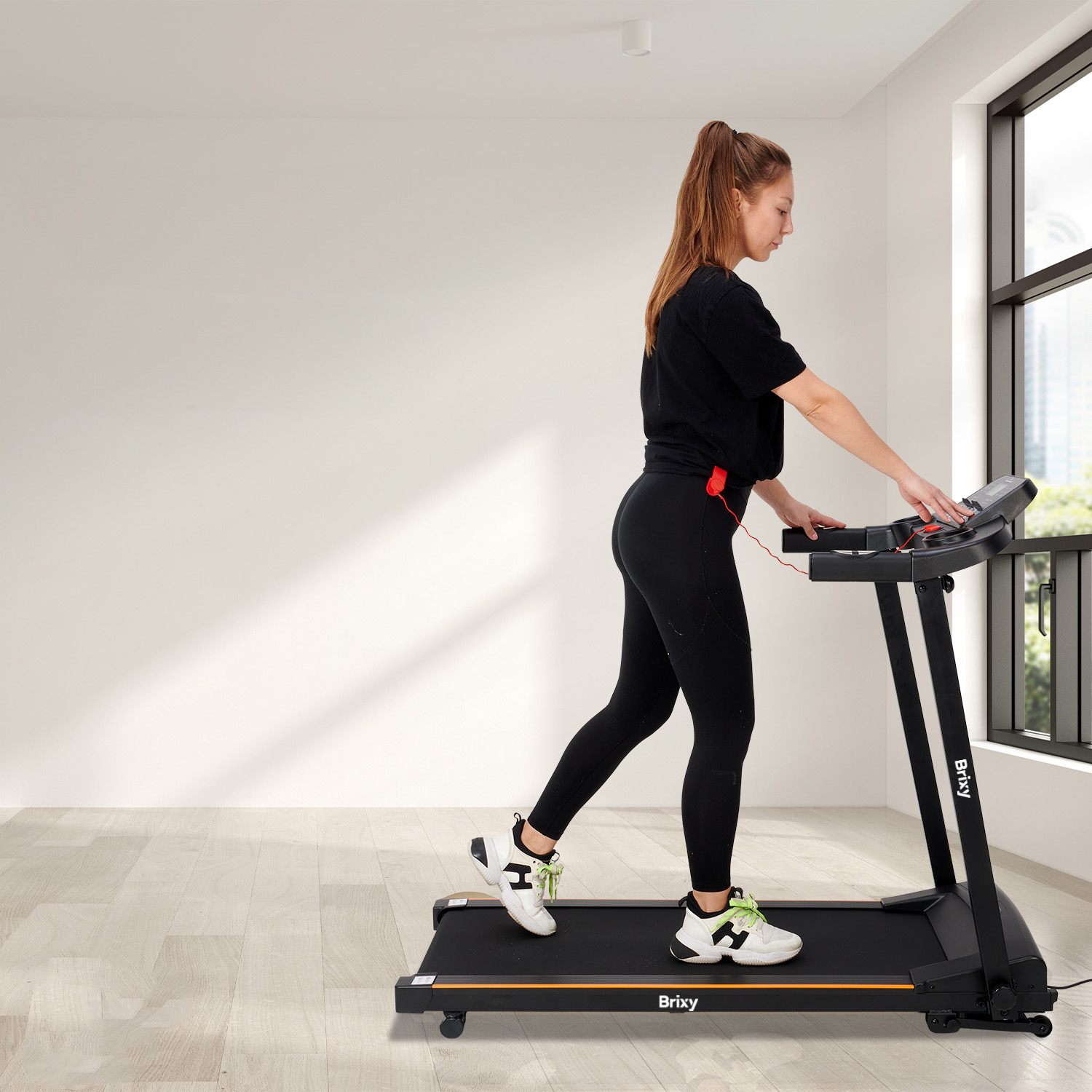 Woman exercising on a treadmill, wearing black shirt and leggings.