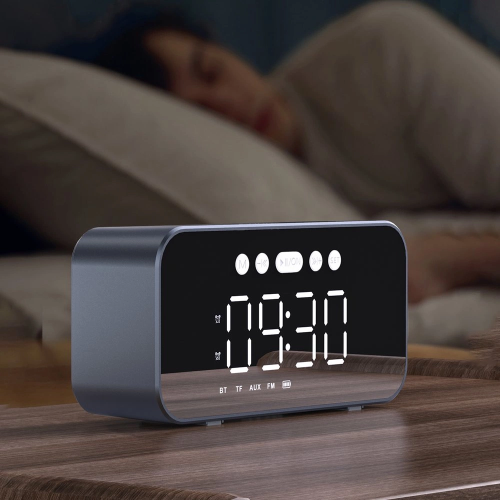 Digitaler Wecker mit Spiegeldisplay zeigt 09:30 an. Person schläft im Hintergrund.