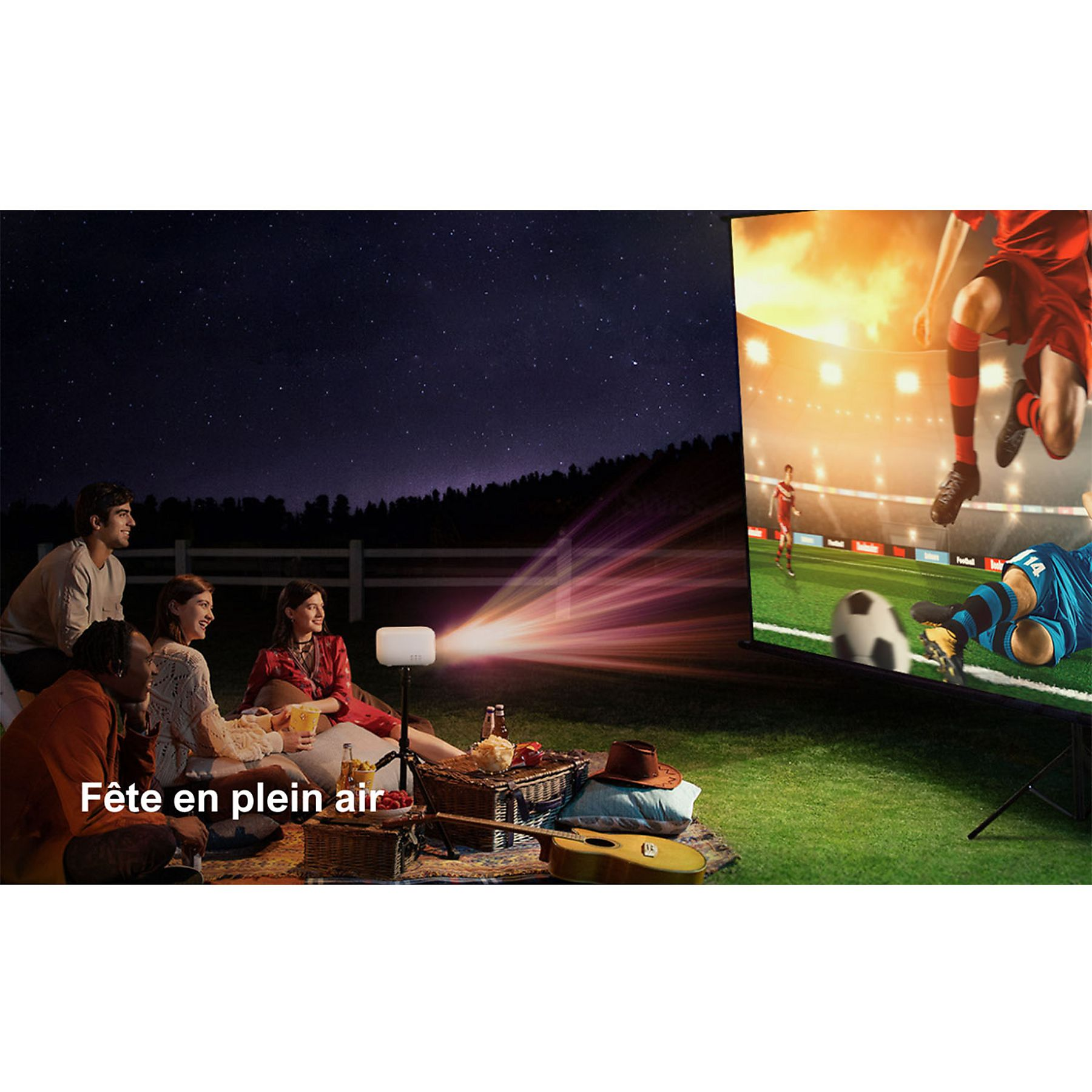 Des gens regardent du football en plein air la nuit sous les étoiles, projeté sur écran.