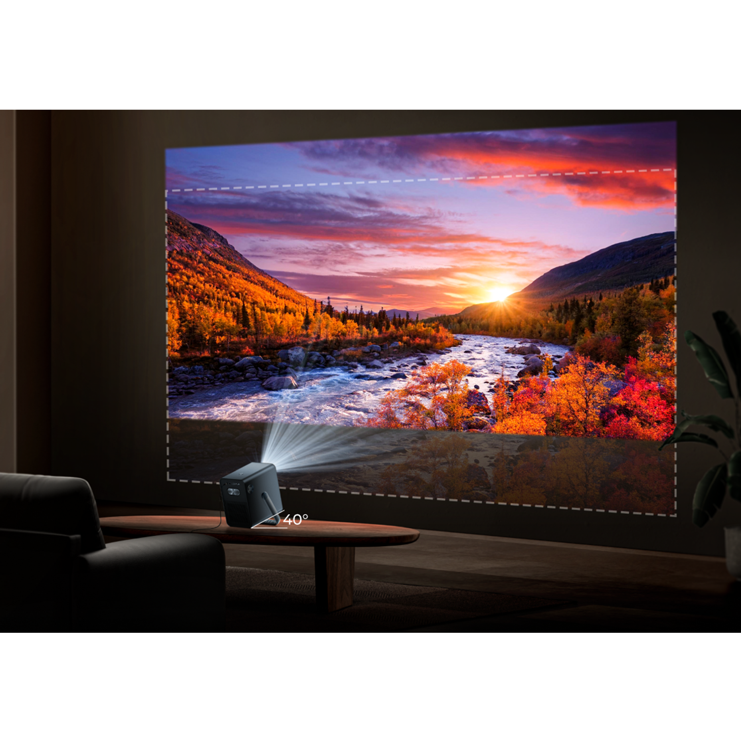A projector displays an autumn forest scene with a river at sunset.