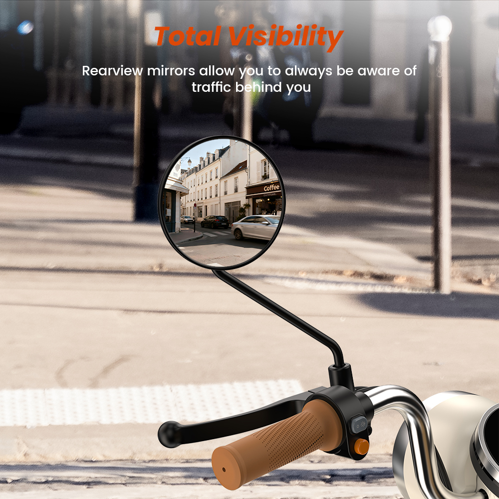 Lusterko motocyklowe pokazuje ulicę z budynkami i samochodami.