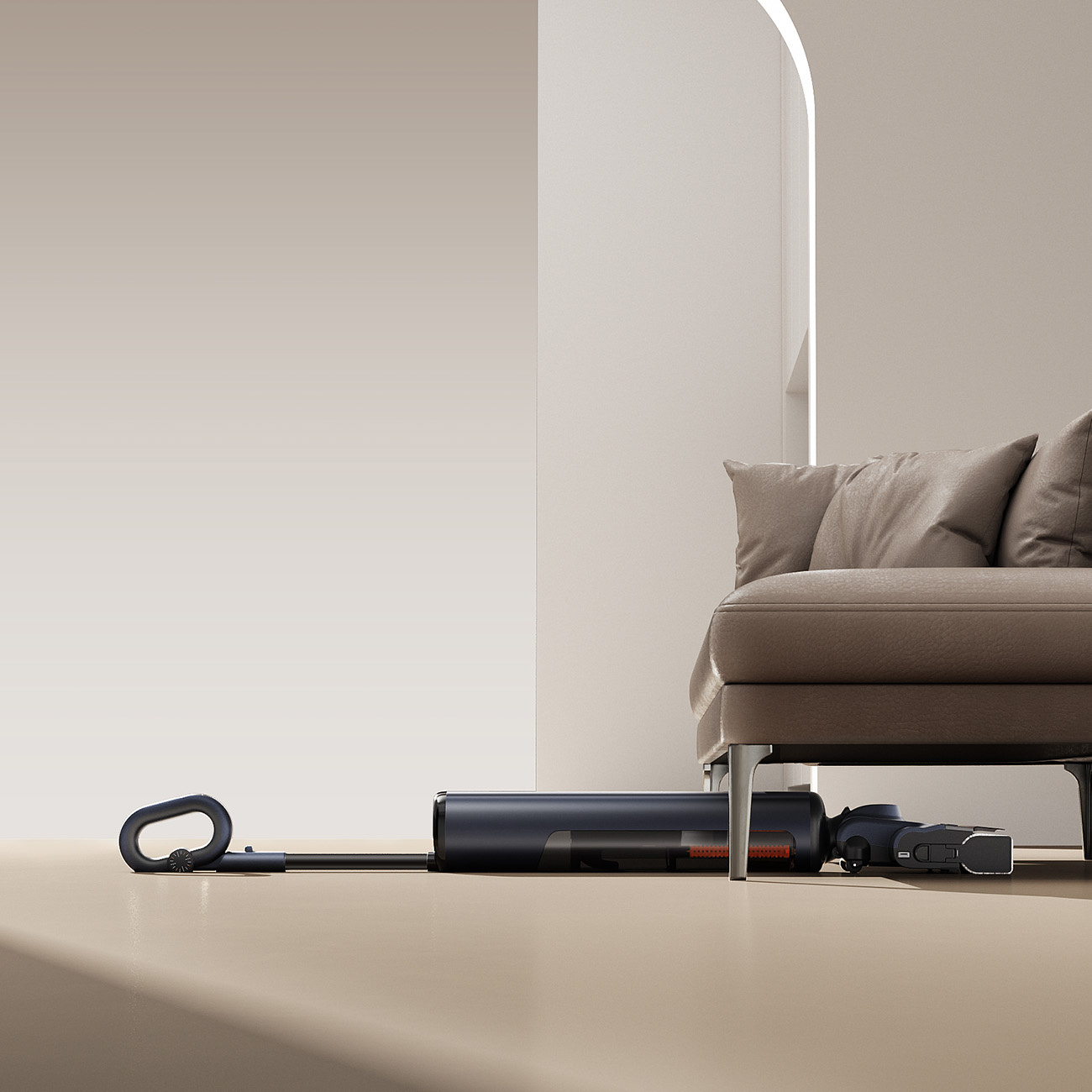 Ciemny odkurzacz akumulatorowy leży pod kanapą na beżowej podłodze.