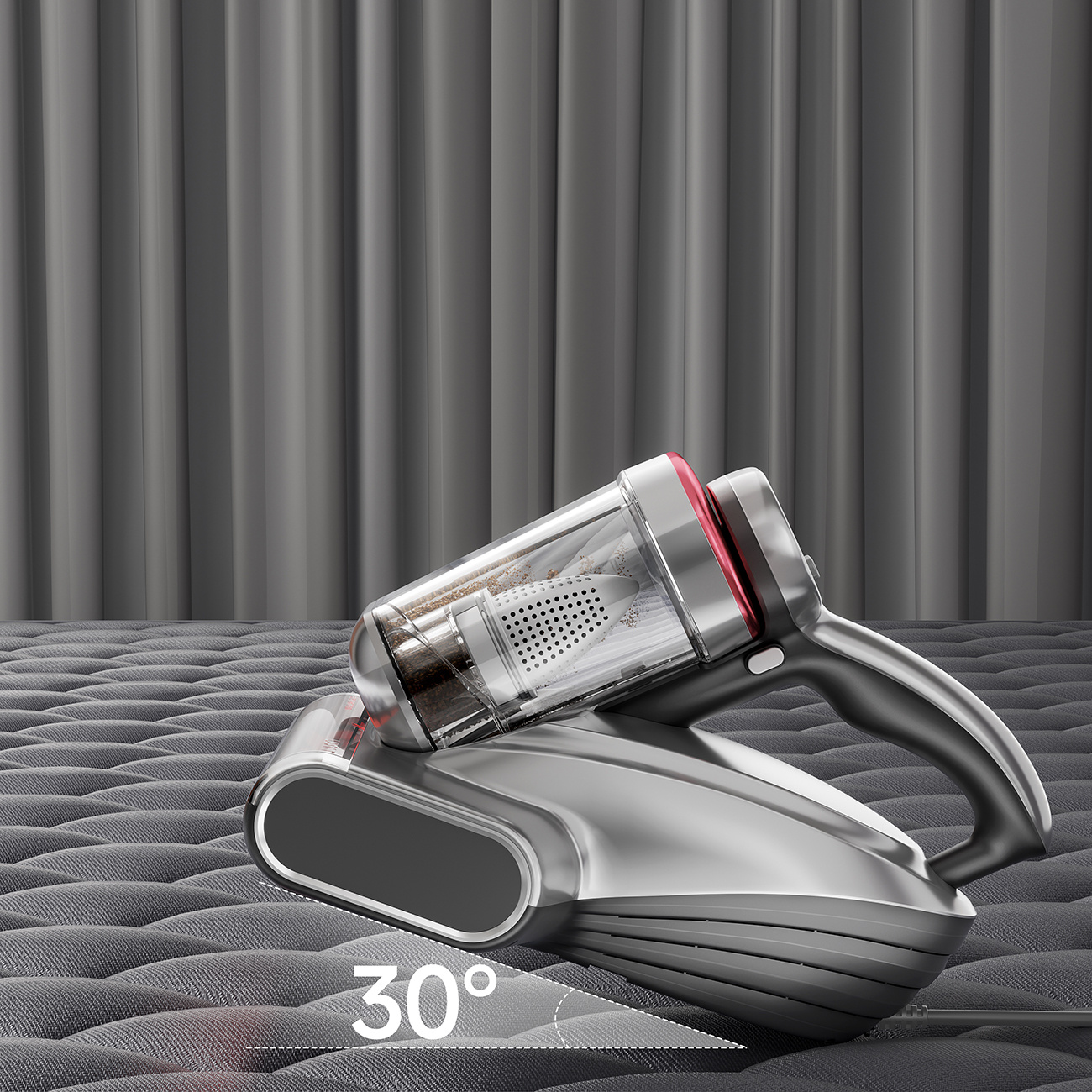 Srebrny odkurzacz ręczny z przezroczystym pojemnikiem leży na szarej powierzchni.