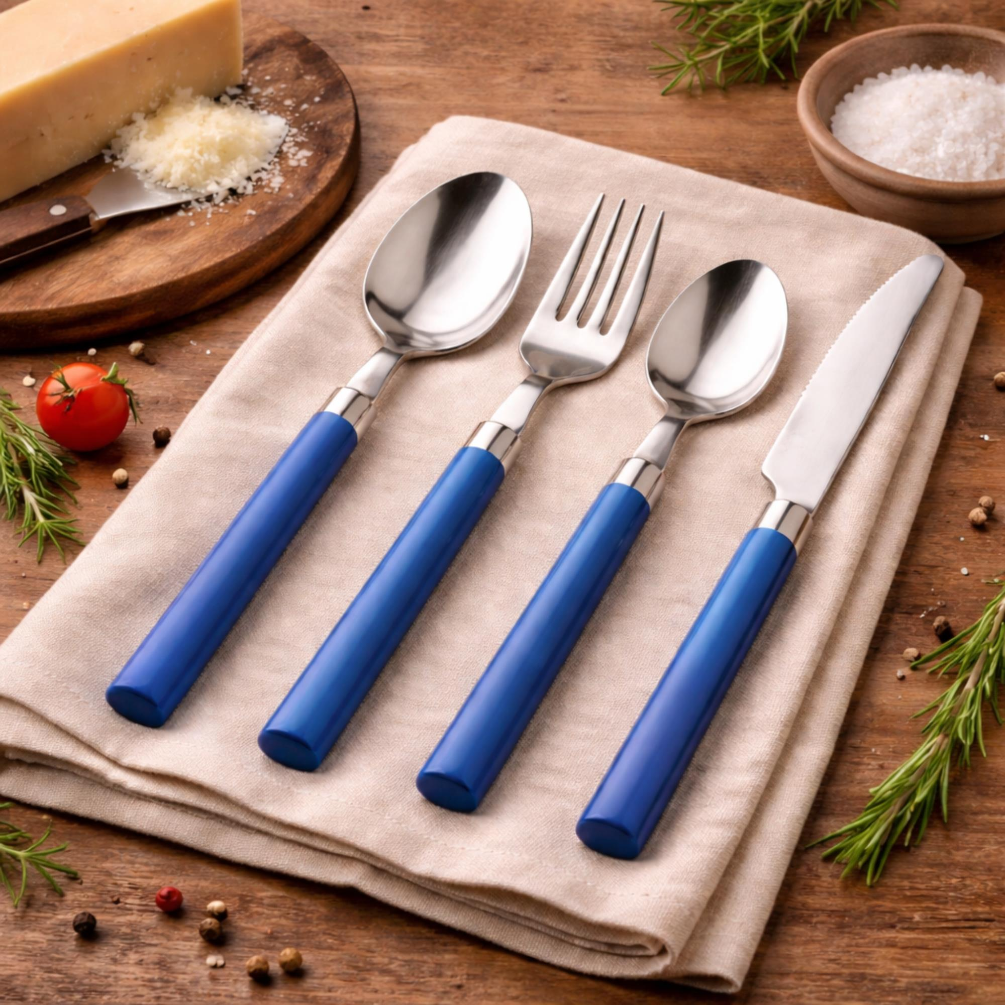 Cubiertos con mangos azules sobre tela de lino con parmesano, tomate y romero.