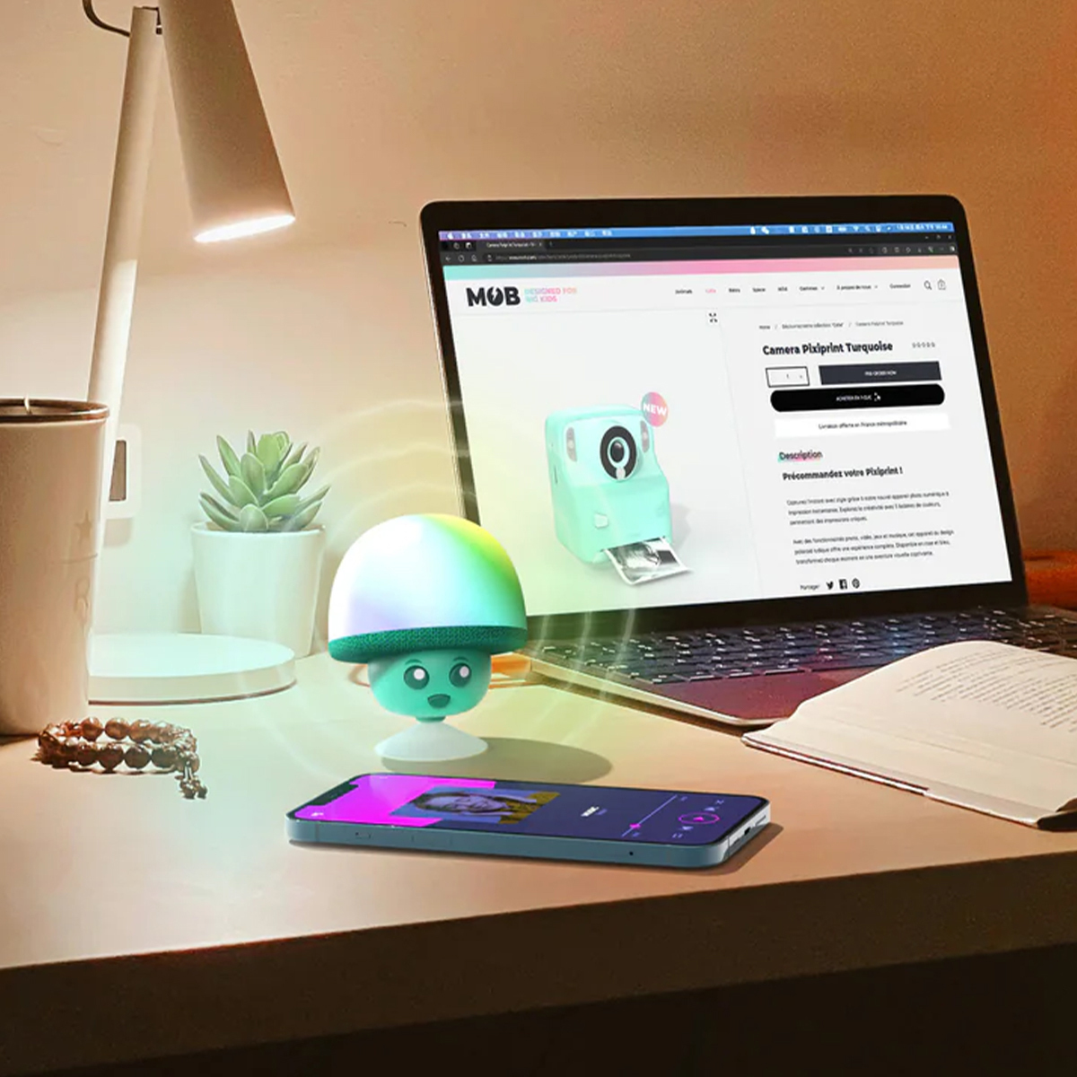Una scrivania con lampada, laptop, telefono, lampada carina e pianta succulenta.