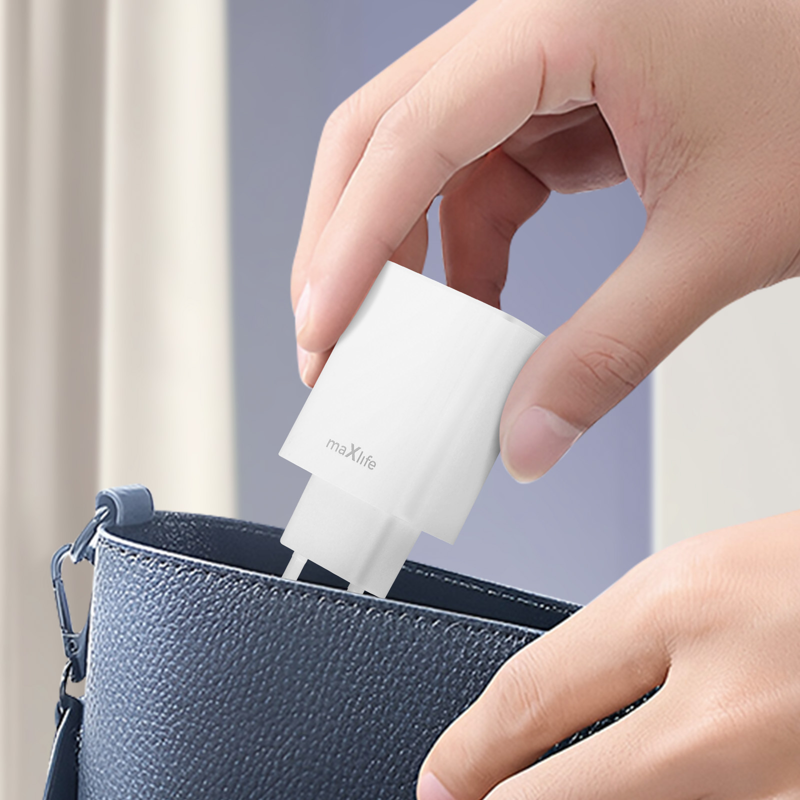 Un caricatore bianco Maxlife viene messo in una borsa blu.