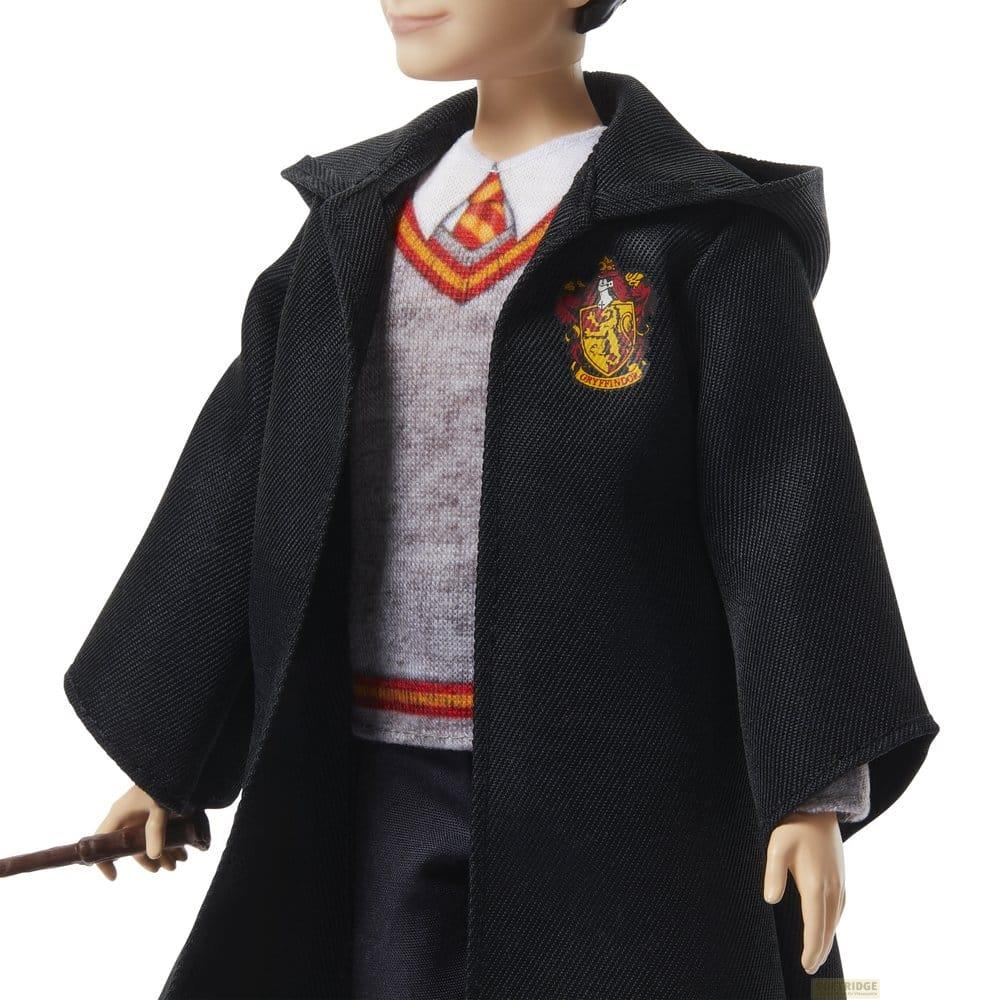 Une poupée Harry Potter porte une tenue Gryffondor avec une cape.