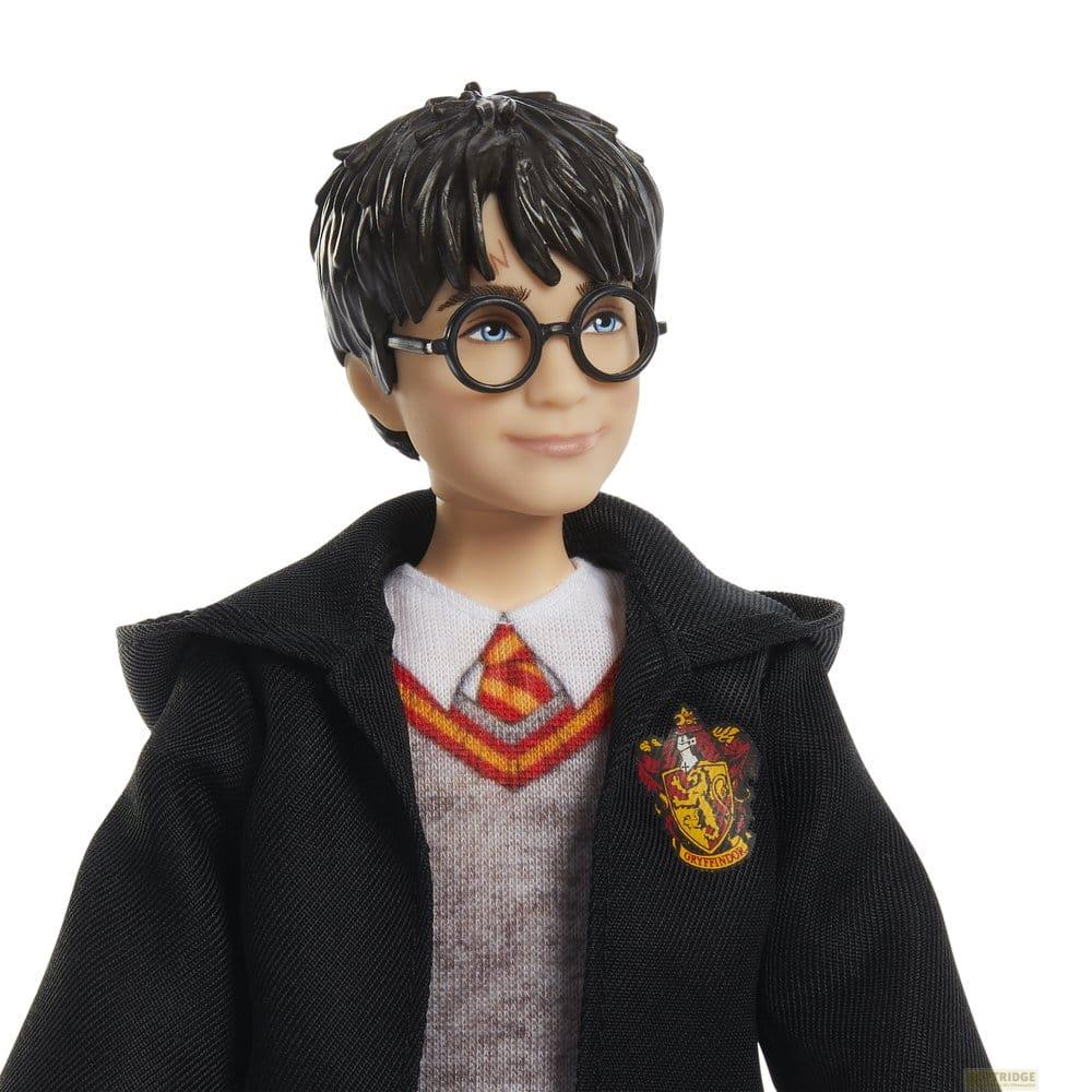 Poupée Harry Potter portant des lunettes, un blason Gryffondor et une cape.