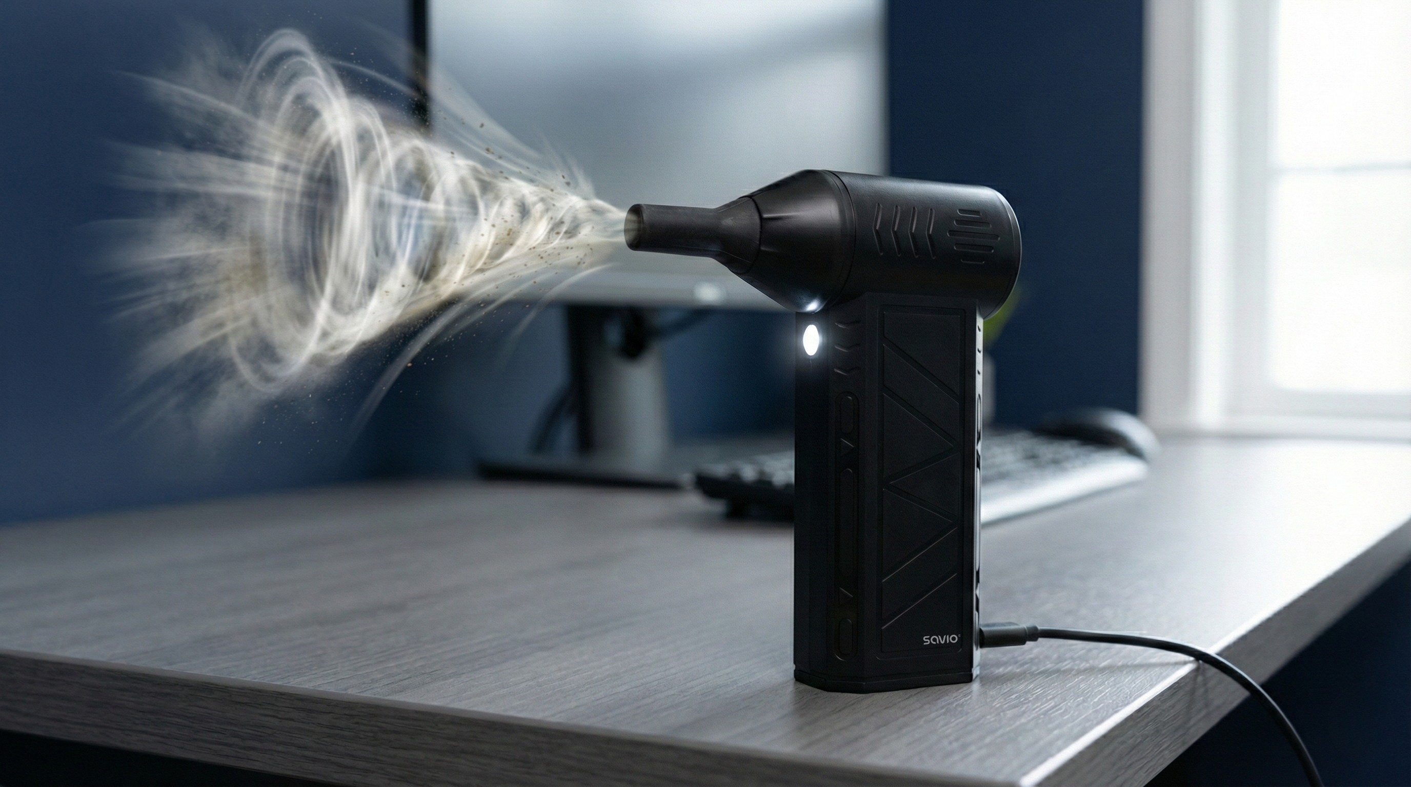 Czarny odkurzacz przedmuchuje cząsteczki kurzu w wirujących wzorach.