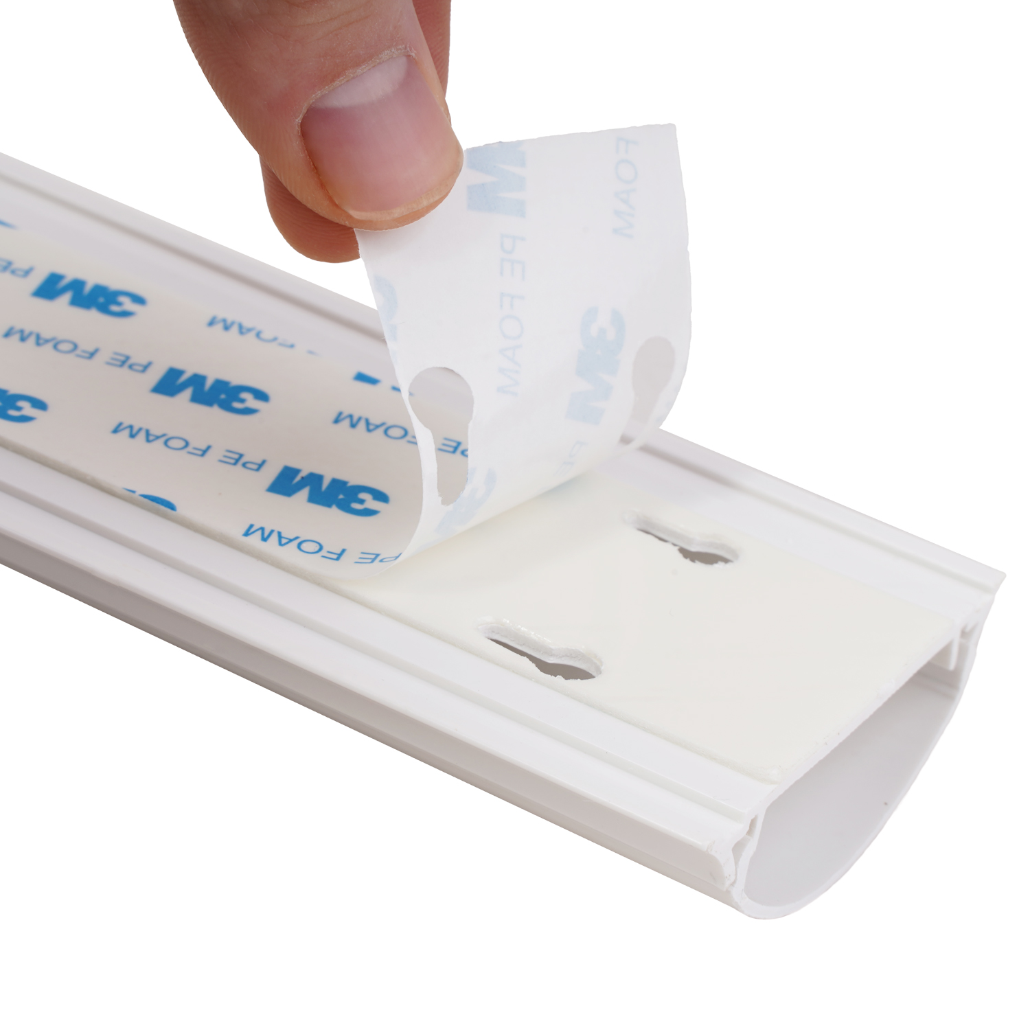 Finger zieht Schutzfolie von weißem Kabelkanal mit 3M Klebeband ab.