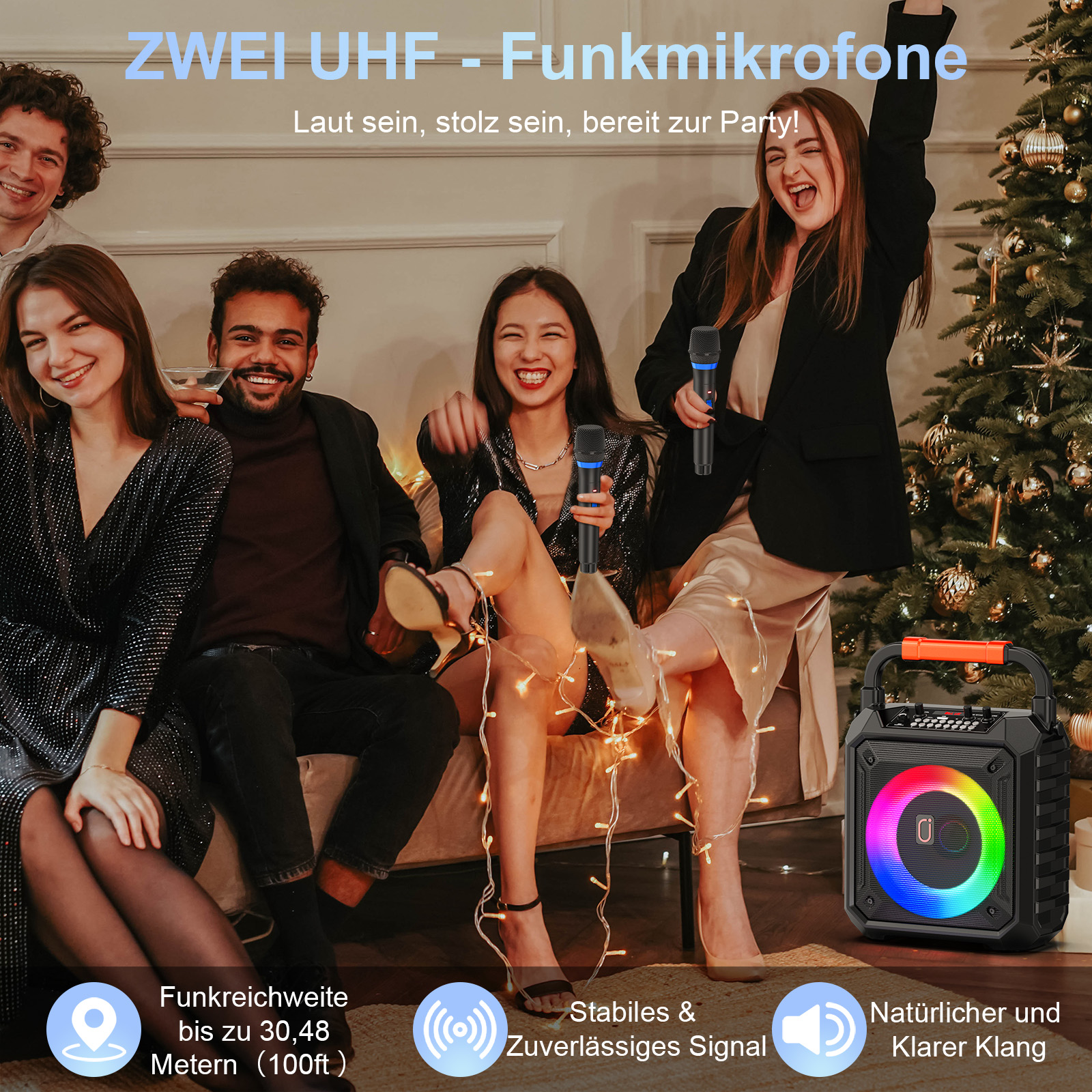 Vier lachende Menschen mit Mikrofonen und Lautsprecher, Party-Atmosphäre.