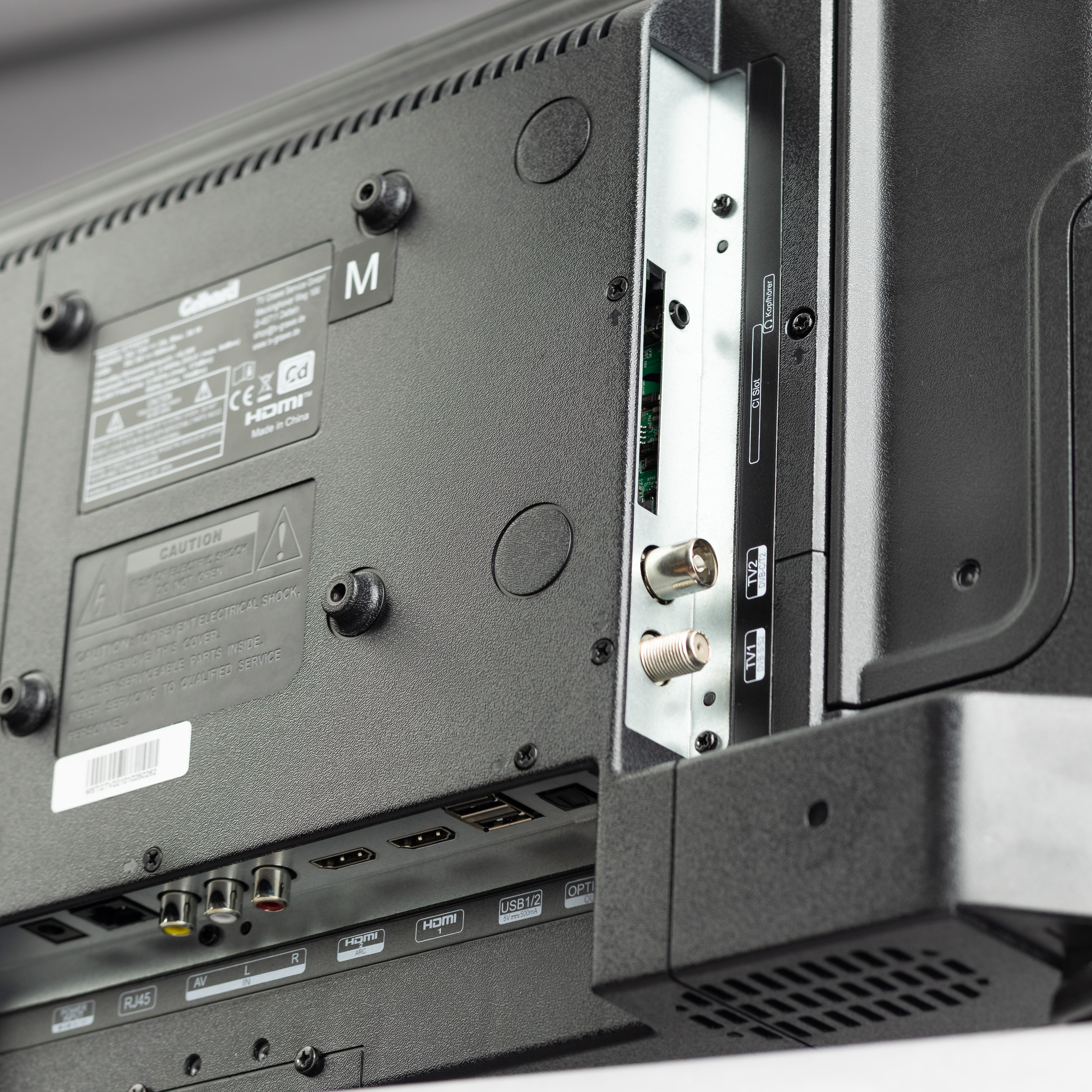 Rückseite eines Fernsehers mit Anschlüssen wie HDMI, USB, AV und Koaxialbuchsen.