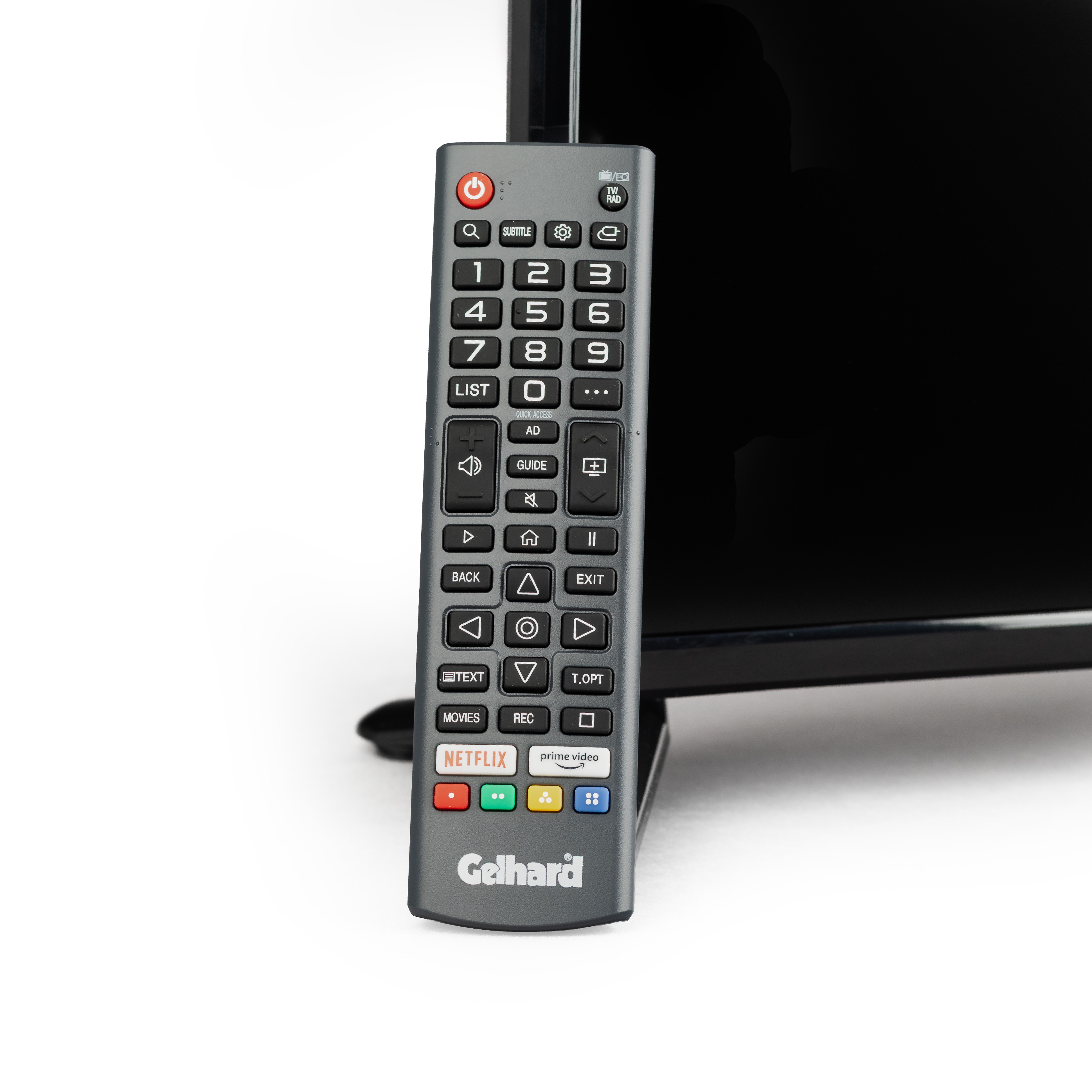 Grauer Fernbedienung mit Netflix- und Prime Video-Tasten neben einem schwarzen Fernseher.