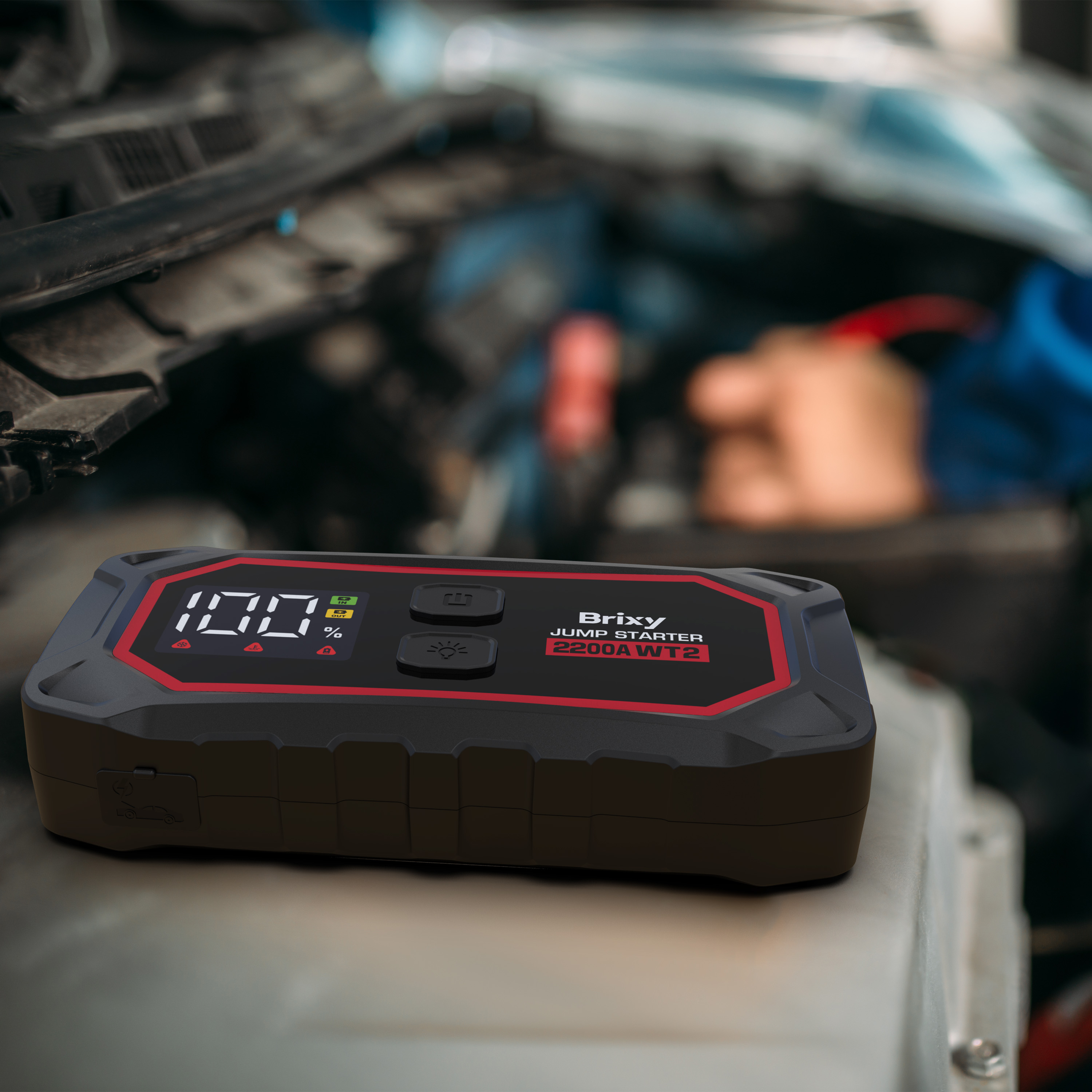 Een zwarte startbooster met rode rand toont 100% lading.