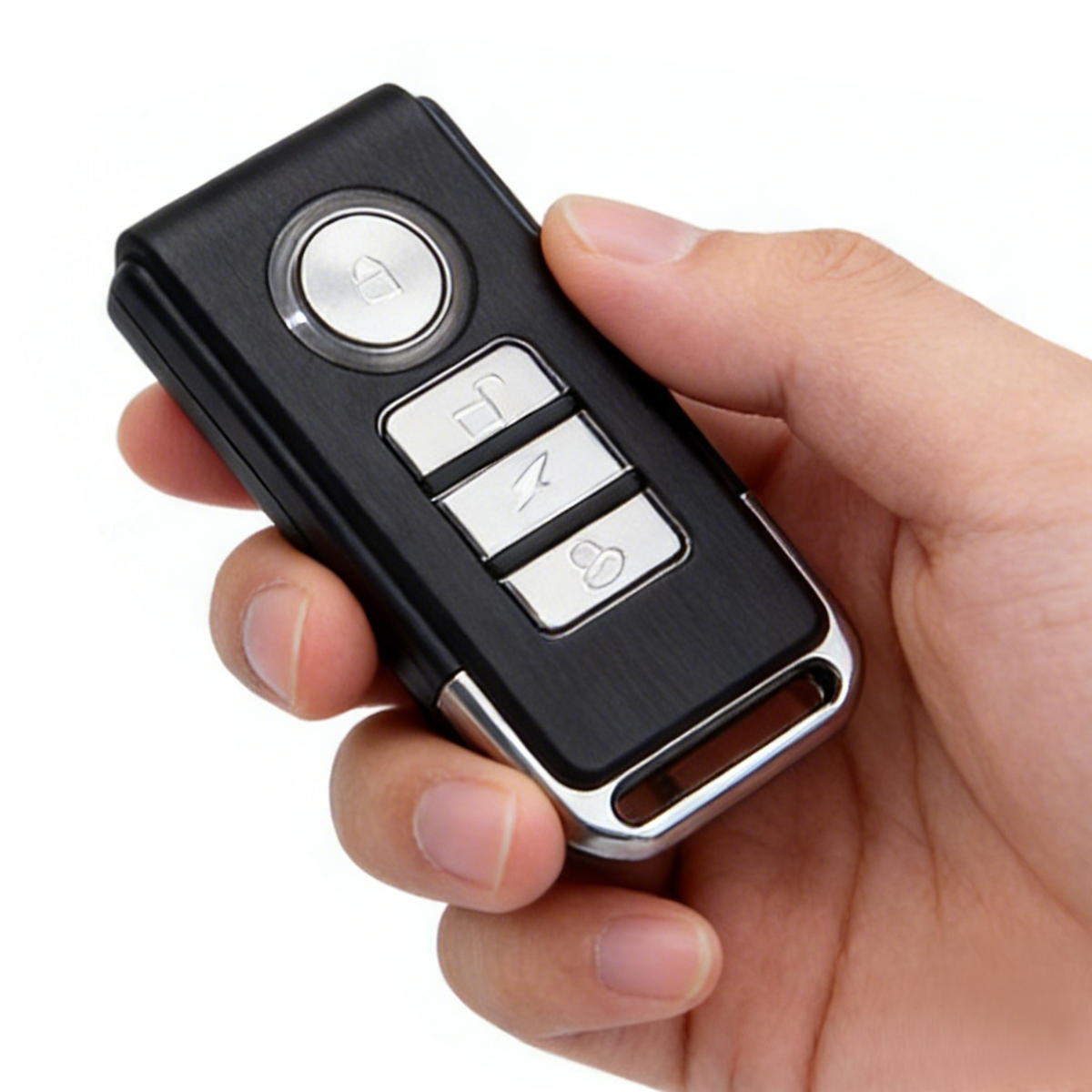 Een hand houdt een zwarte autosleutel met vier zilveren knoppen vast.