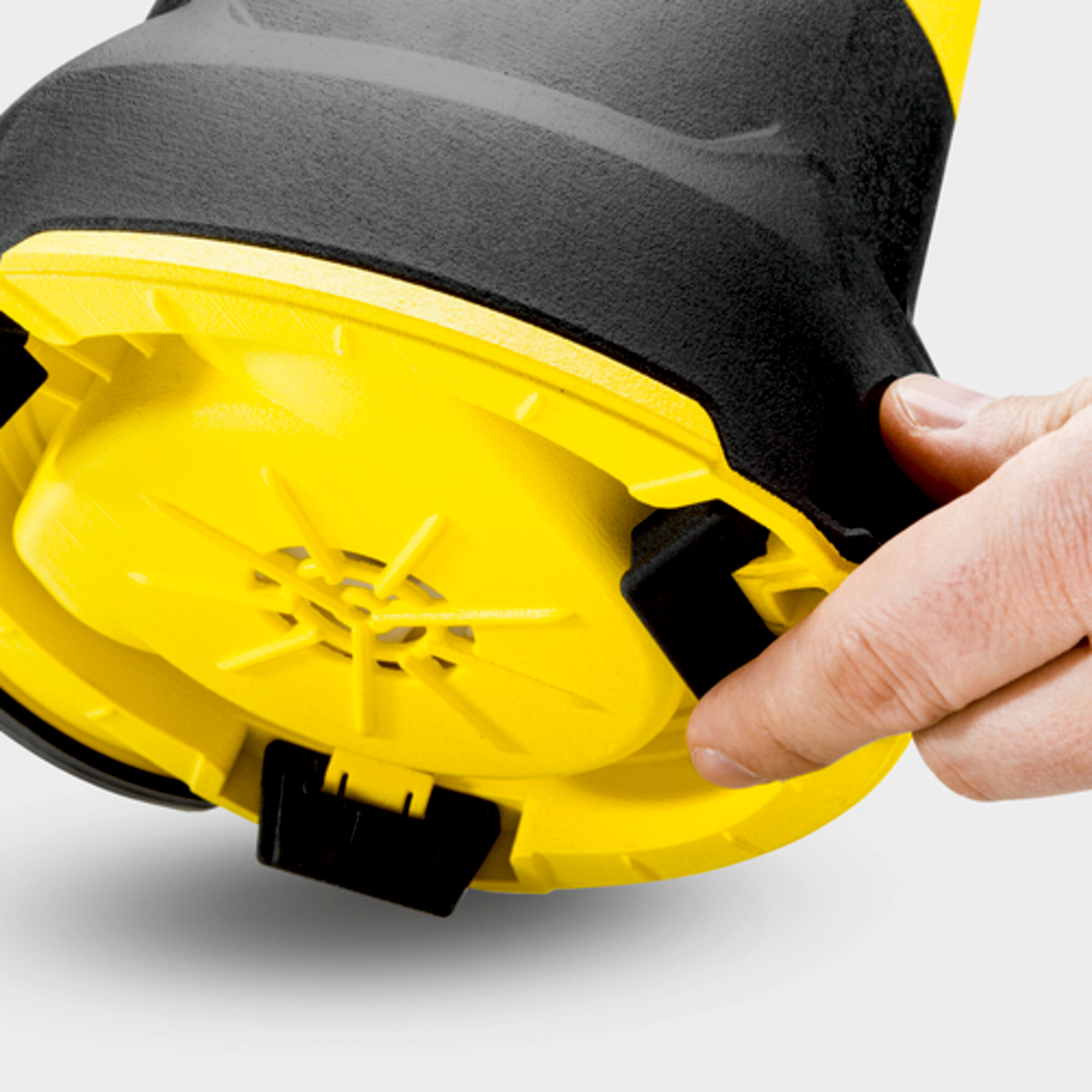 Palec naciska czarny klips na żółtym urządzeniu.