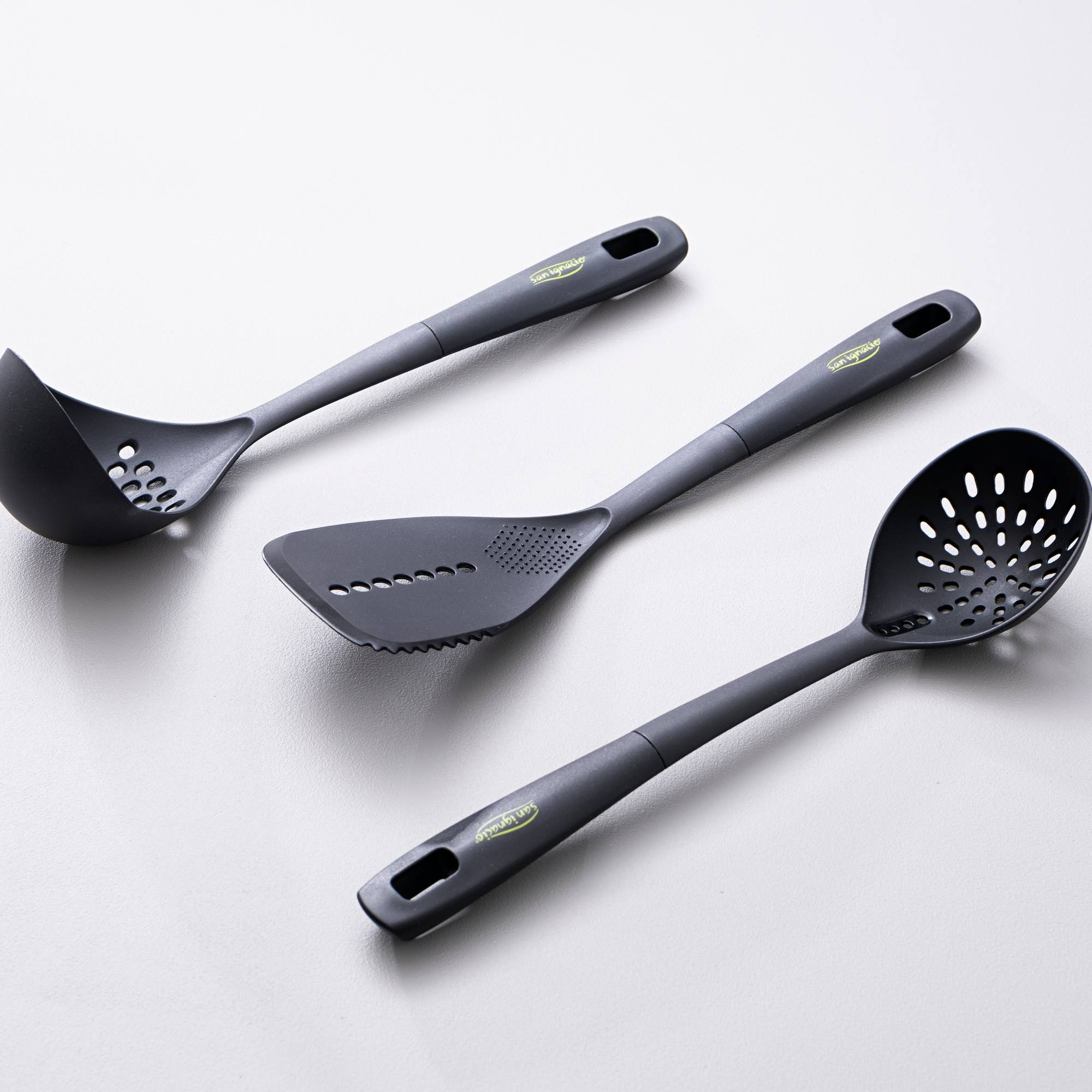 Tres utensilios de cocina grises: un cucharón, una espátula y una espumadera.